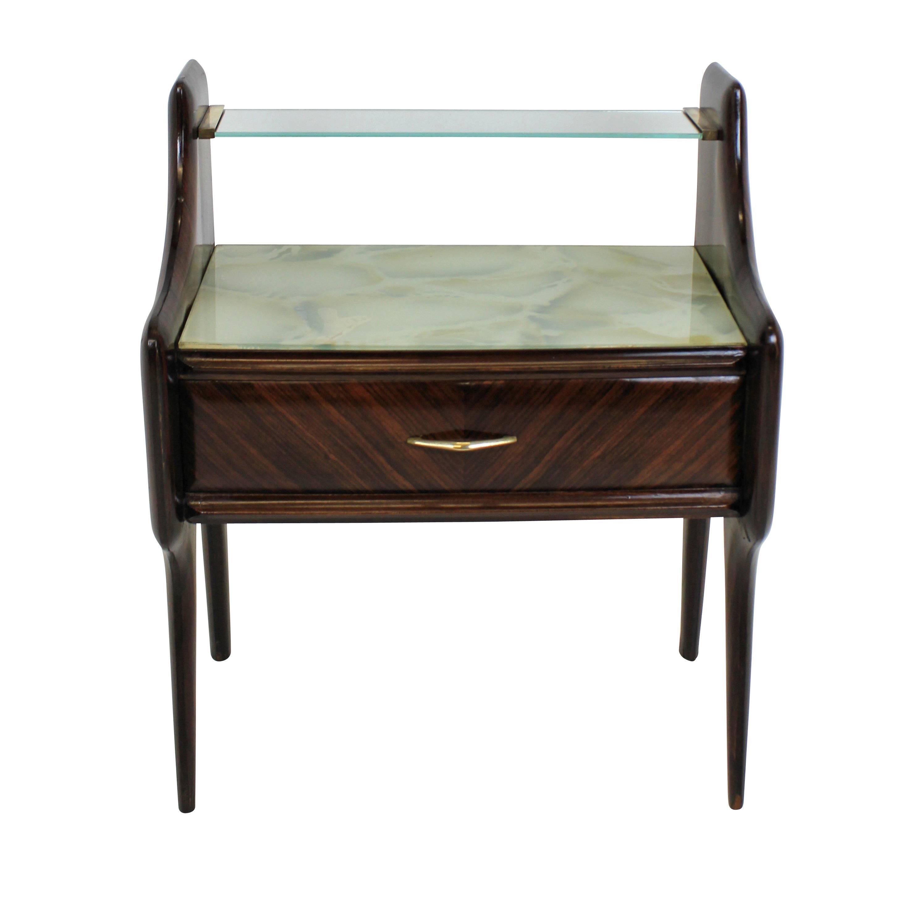 A pair of Italian Mid-Century nightstands in rosewood, with faux marble glass tops, a glass shelf and central drawer.