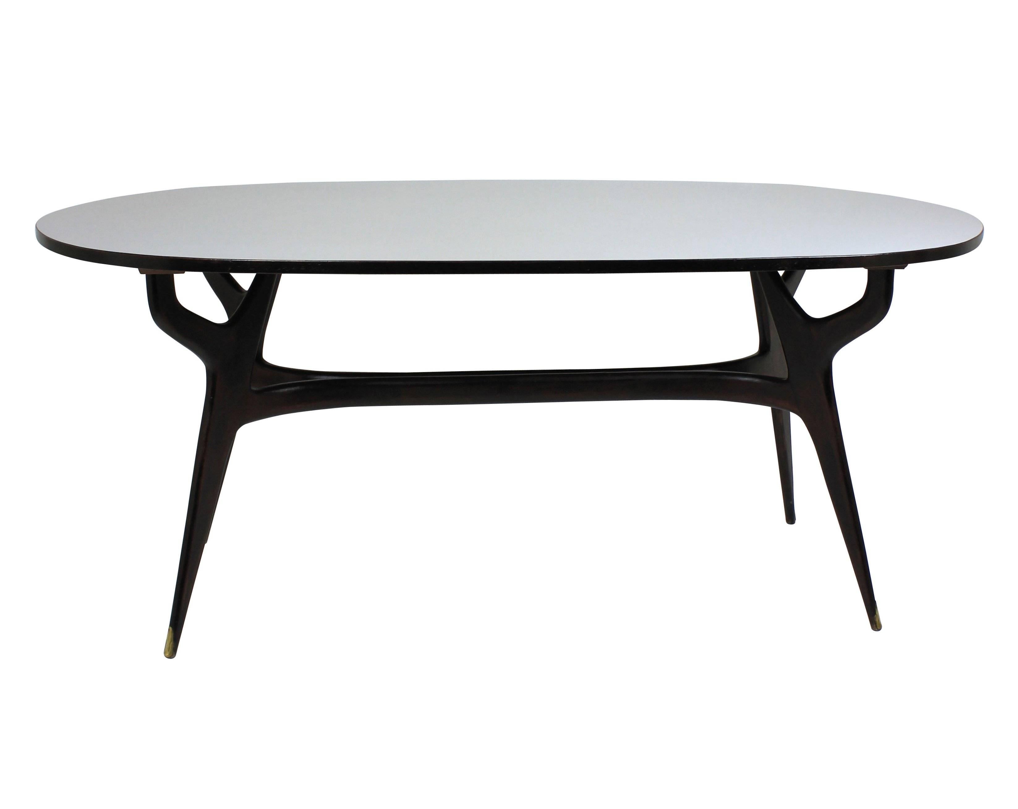 A sculptural dining table by Ico Parisi, in dark wood (not black) and with its original pale grey melamine top in great condition. With brass sabot feet.
