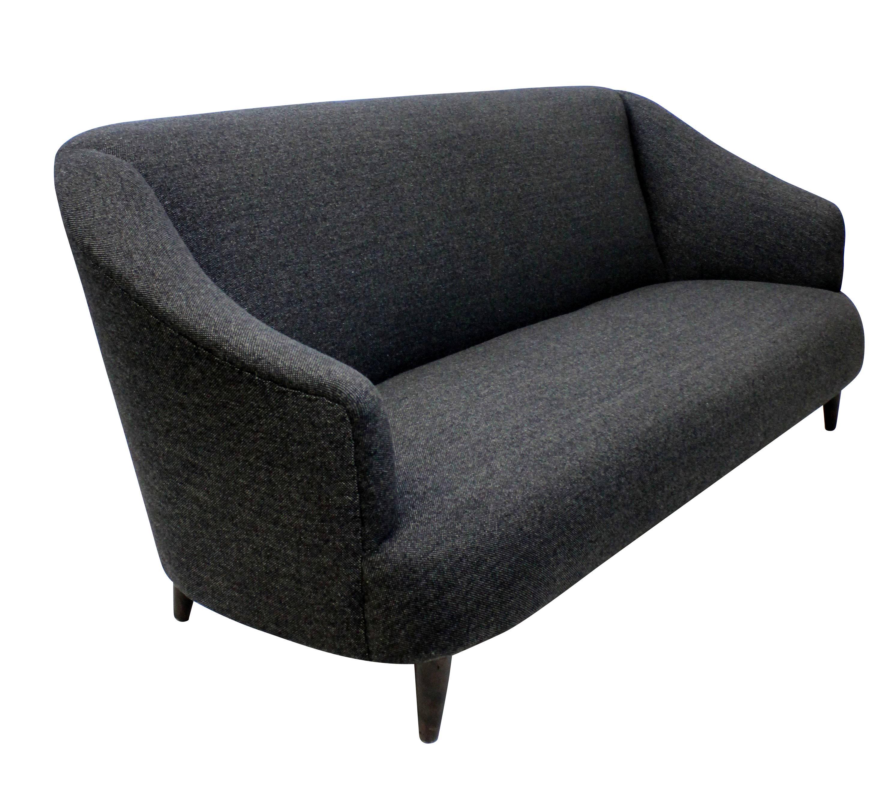 A large sculptural three-seat settee by Ulrich. Newly upholstered in dark grey wool.