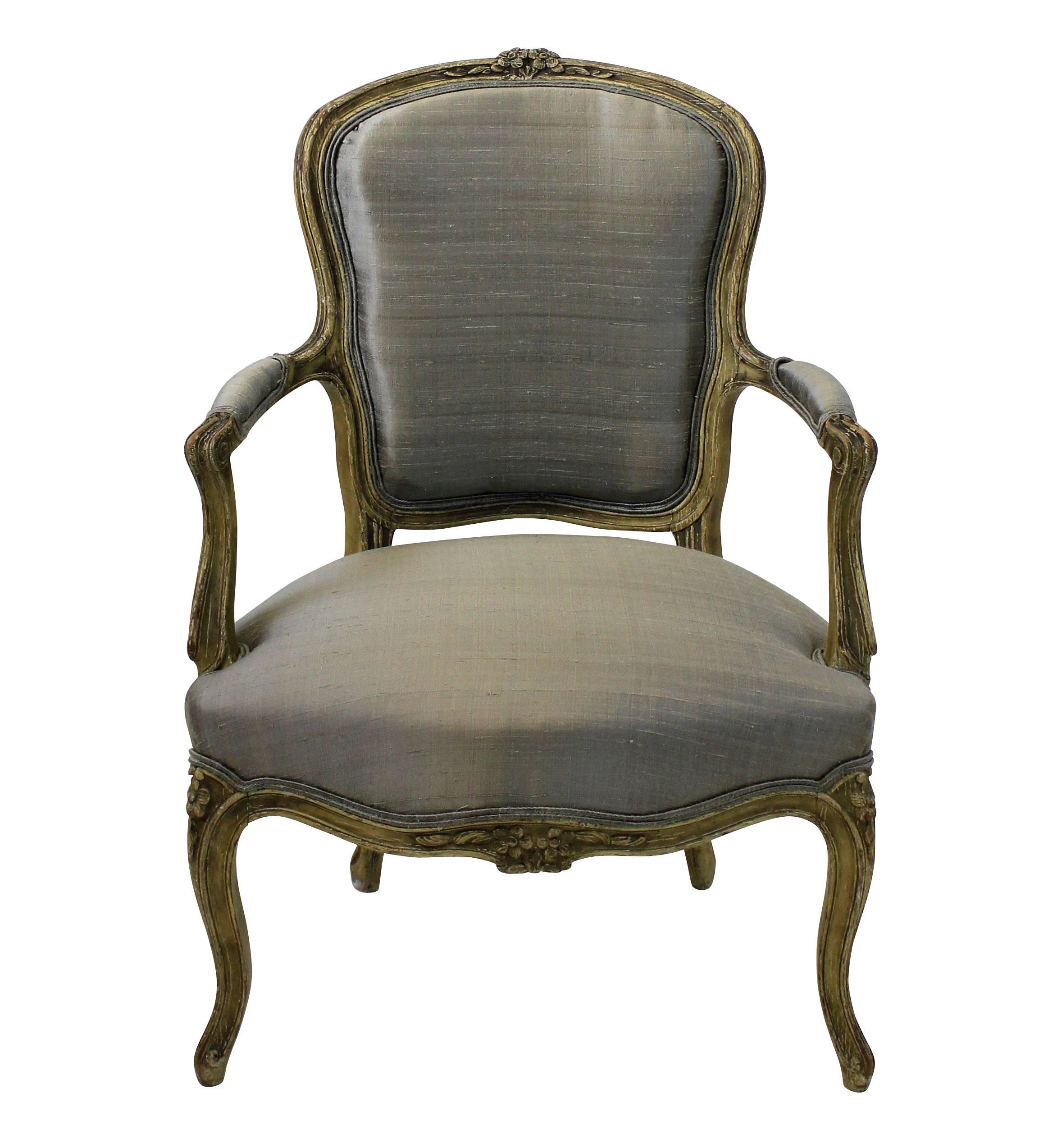 A pair of late 18th century French armchairs in their original paints. Newly upholstered with horsehair padding in stone colored dupion silk.
