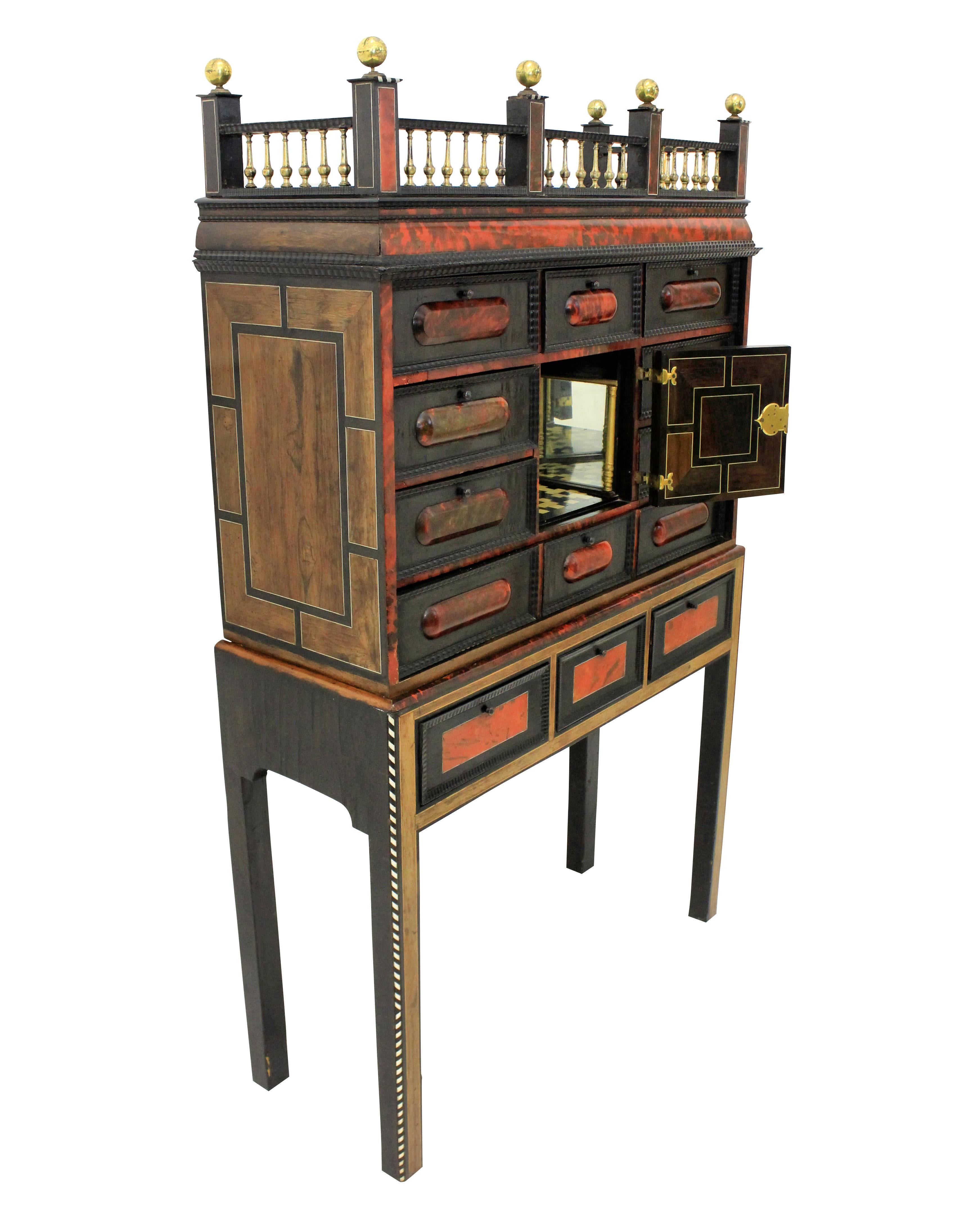 A fine late 17th century Flemish cabinet on stand. The red-stained tortoiseshell with ebony, moulded cornice and ormolu gallery, above a paneled drawer and door enclosing a fitted, perspective interior with a mirrored colonnade and chequered floor