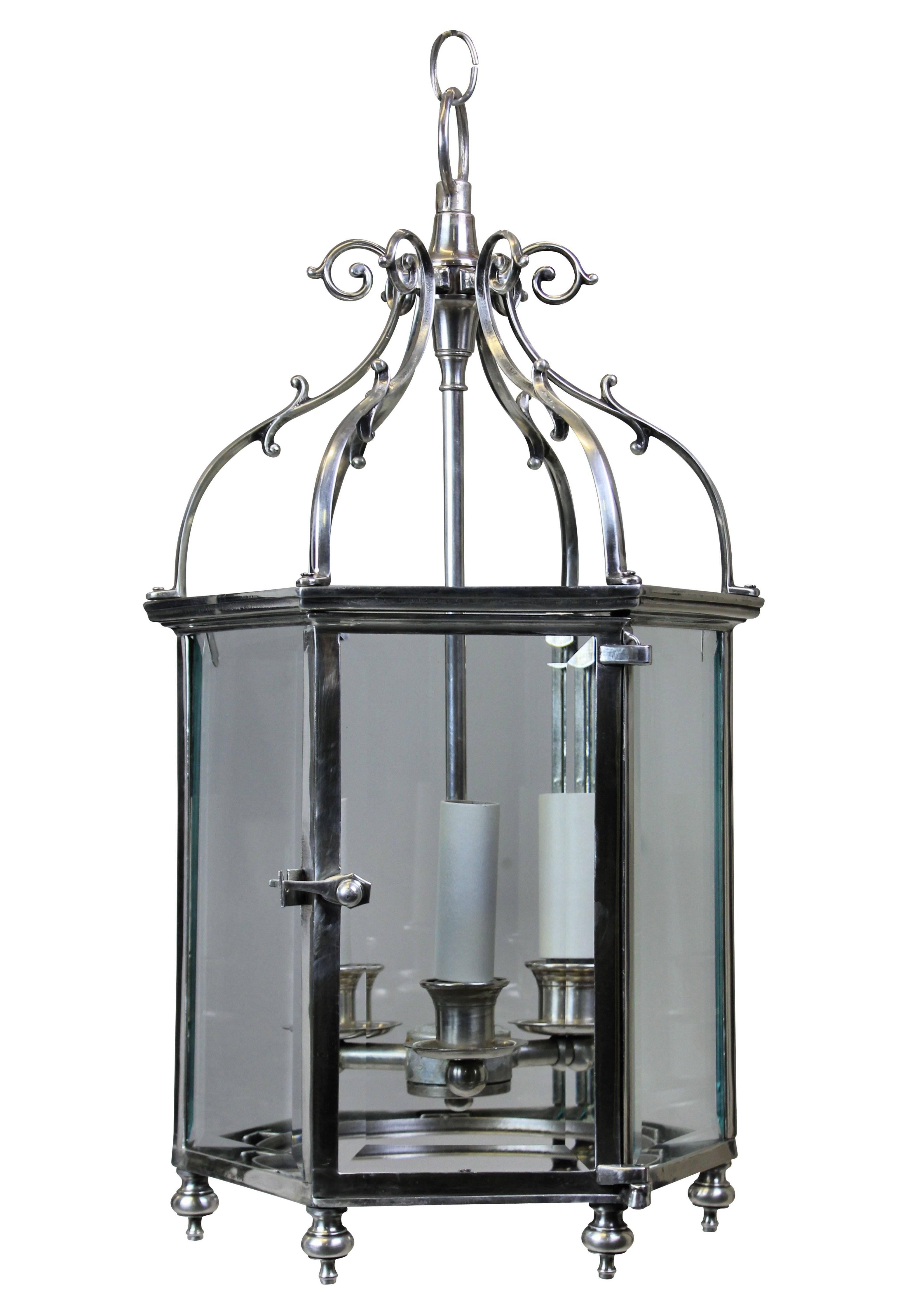A pair of English silver plated Georgian style hexagonal lanterns, each glazed panel in beveled glass with a door.
 