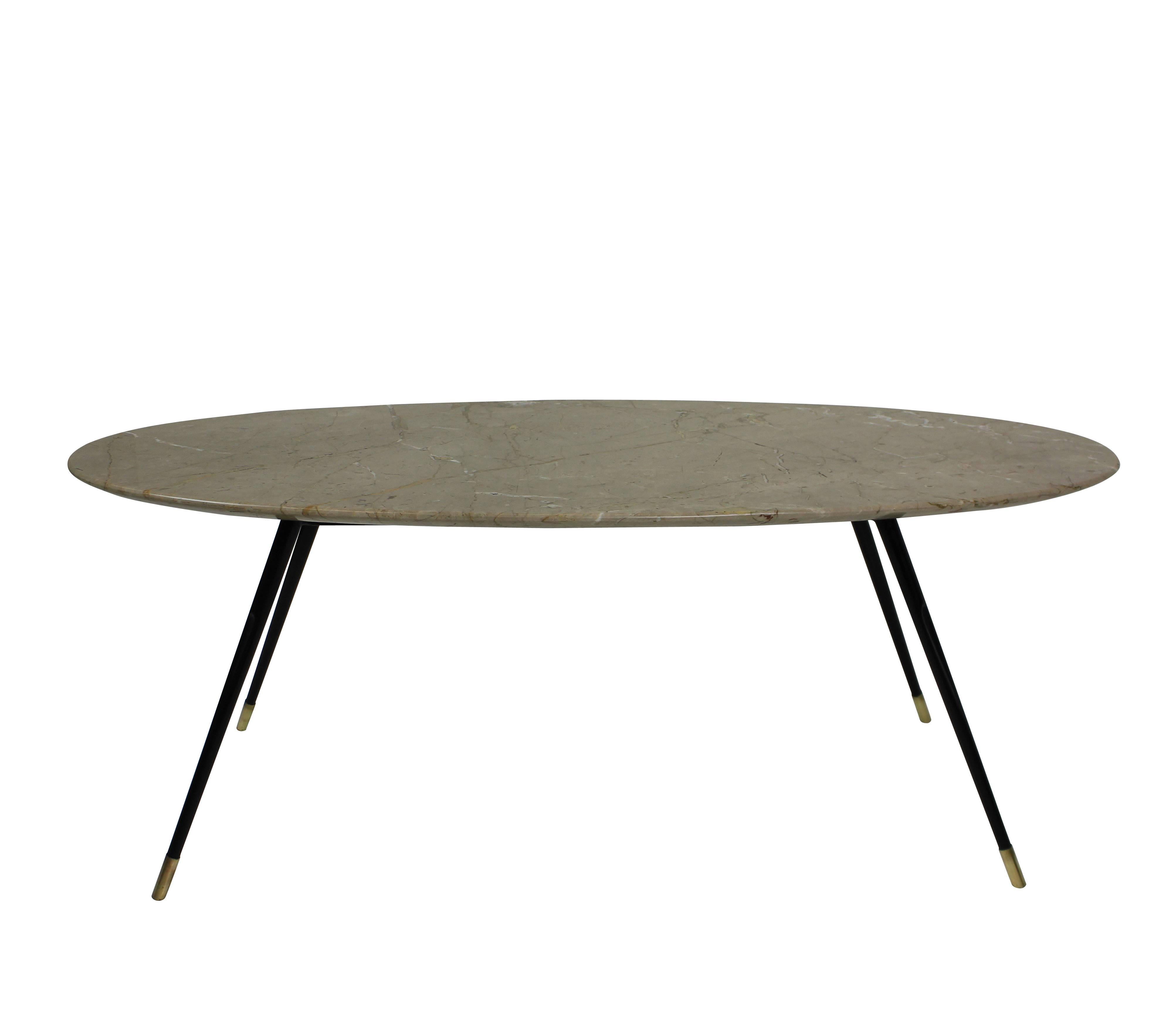 An Italian occasional table of linear and stylish design. On thin tapering black enamel legs with brass feet supporting the navette shaped stone colored marble top.
  