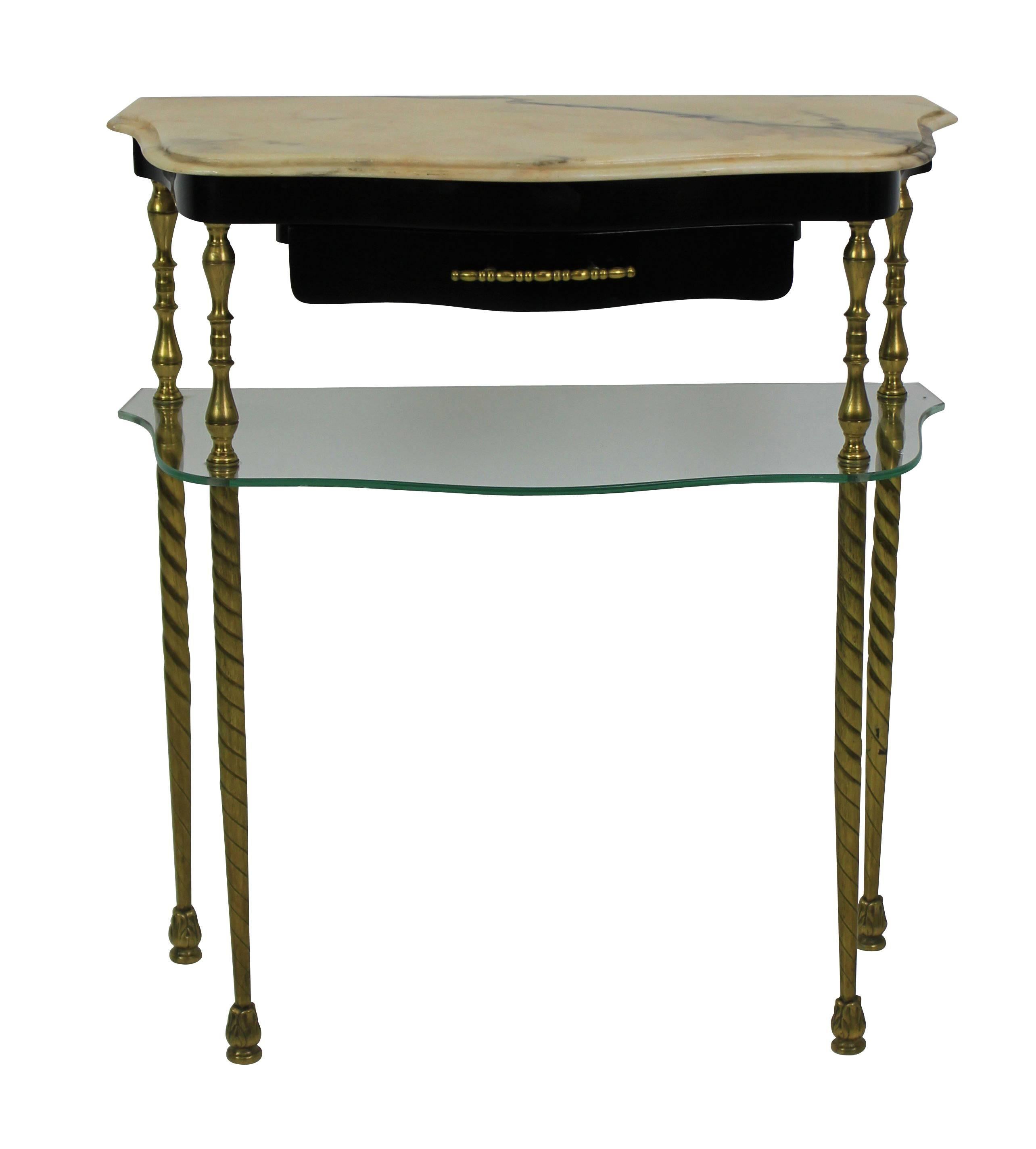 A pair of Italian nightstands in brass, with shaped glass shelves and marble tops with an ebonized frieze and drawer.