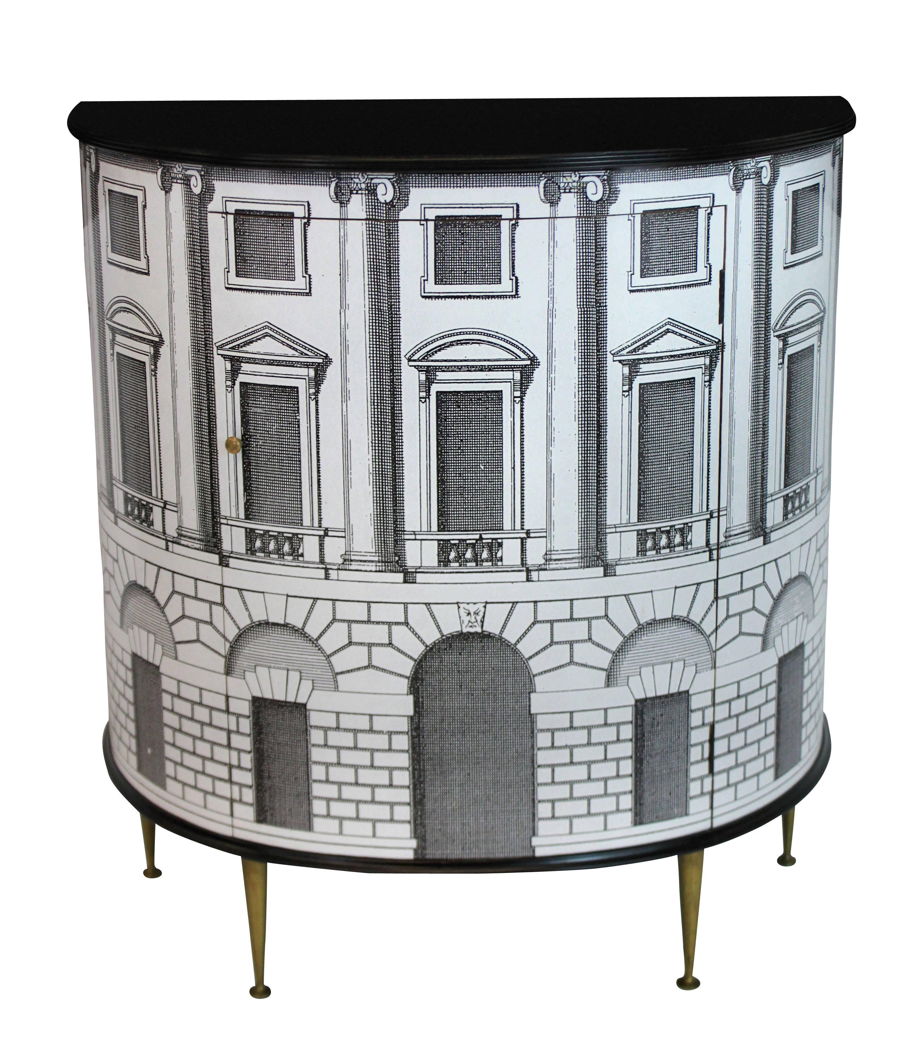 An elegant Fornasetti style cabinet in a Palladian design on brass legs, with fitted interior for use as a bar.