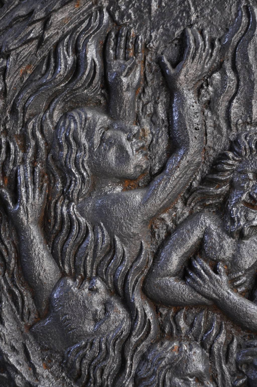 Dated from 1687. In Louis XIV style, the iconography is uncommon : the damned are burning in the Hell (pertinent subject for a fireplace ornament). 
This cast iron fireback is exceptionnal because of the big size of the piece and it's decor. 