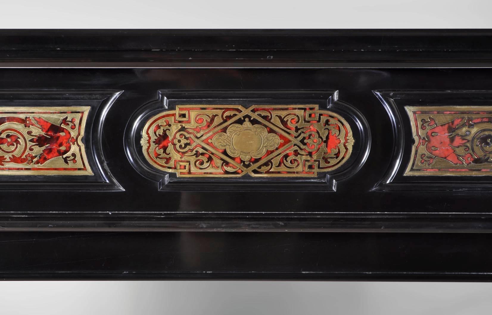 Unusual antique Napoleon III period fireplace sculpted out black marble from Belgium marble with Boulle marquetry inlays. 
This marquetry technique, very decorative, allows a rich polychrome decor. Created during the 17th century in France, this