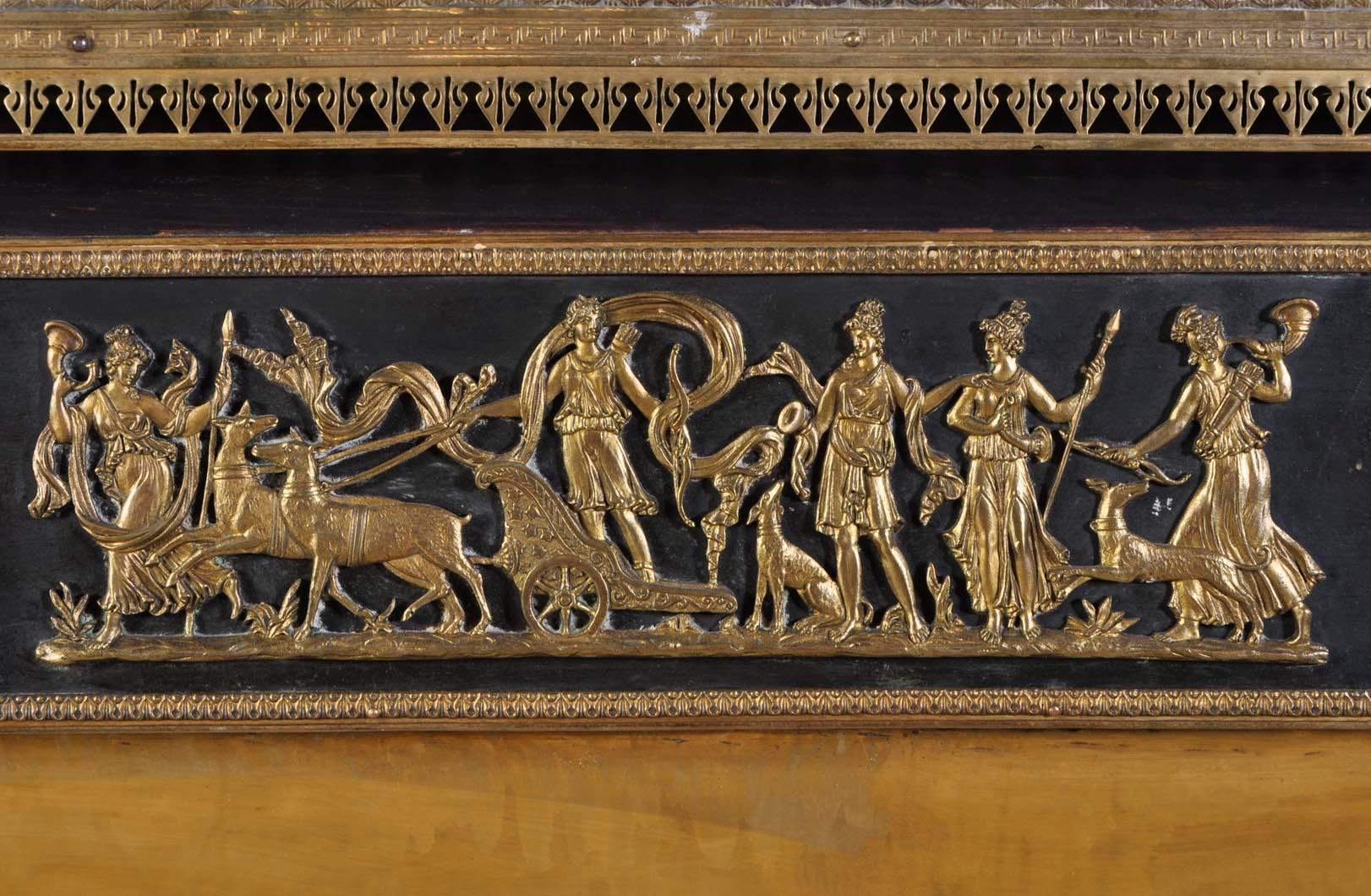 Antique wooden Empire style fireplace with gilt bronze ornaments from the first half of the 19th century.
Stained black wood gives relief to the bronze decorations. The center of the frieze is ornated with a bronze representing a triumph of Diana.