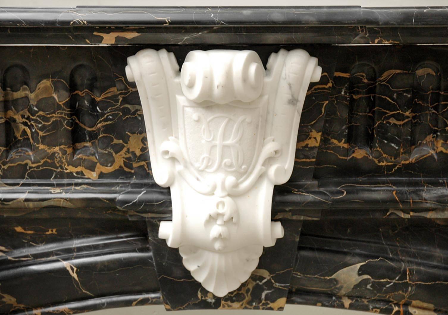This exceptional antique Napoleon III style fireplace was made out of Portor marble and statuary marble in the late 19th century.
This particular design detached columns with statuary marble Corinthians capitals. The center of the entablature bears