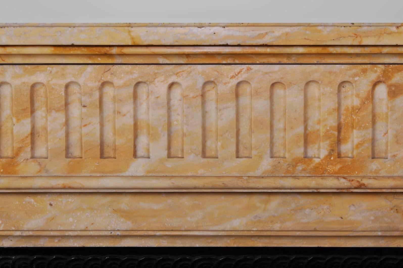 Antique Louis XVI style fireplace made in yellow from Siena marble during the 19th century. Both jambs are half-columns shaped with flutings and features capitals with acanthus leaves.
The frieze is also fluted.
Both sides of the fireplace are