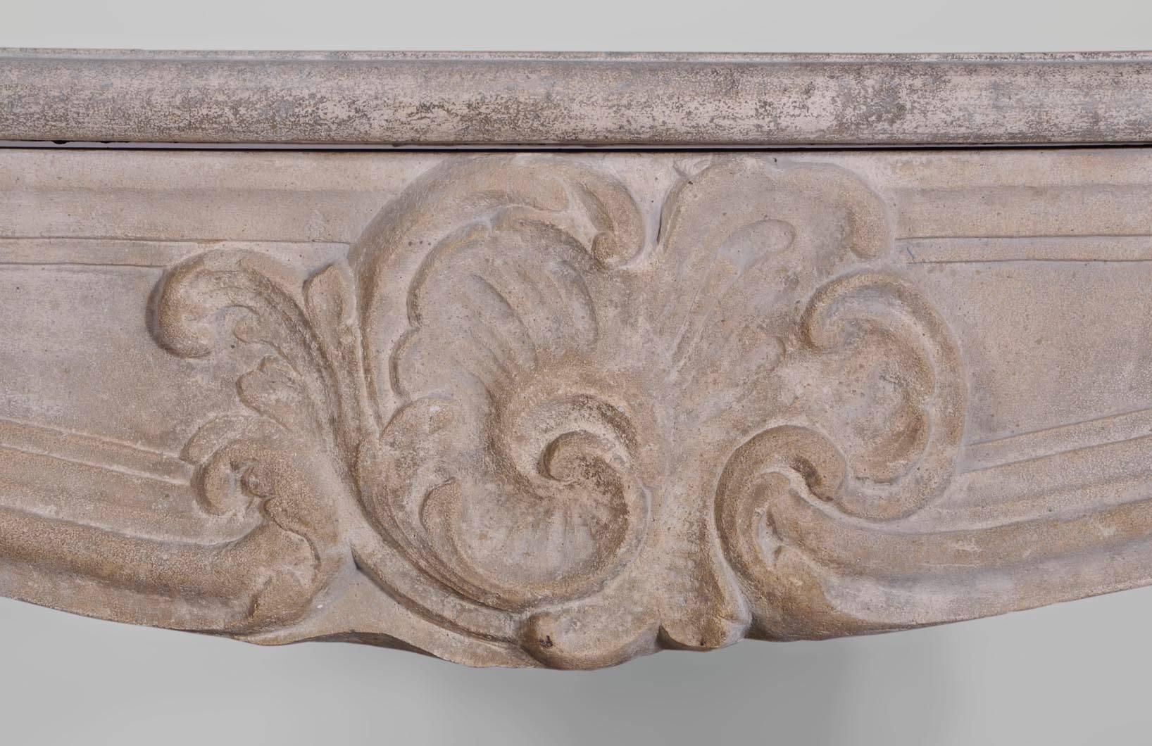 Antique Louis XV style fireplace sculpted out of Euville stone during the 19th century. Curved lines, asymmetrical shell on the centre of the frieze, medallions and panels.