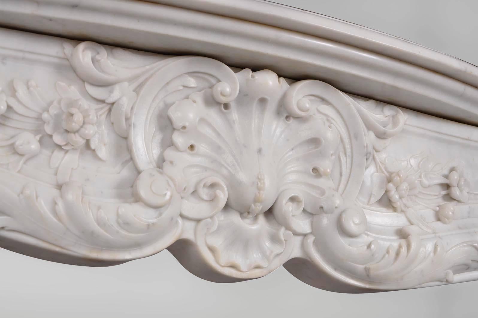 The curved lines are richly carved with foliate shells, acanthus leaves and realistic flowers.
The sides of this fireplace are paneled.