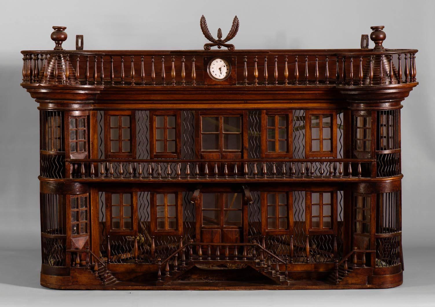 Superb and rare antique bird cage of the late 19th century made out of wood and metal representing a miniature castle adorned with a clock. It is a probable work of mastery: superb quality of the sculptures and refined details with balustrades,