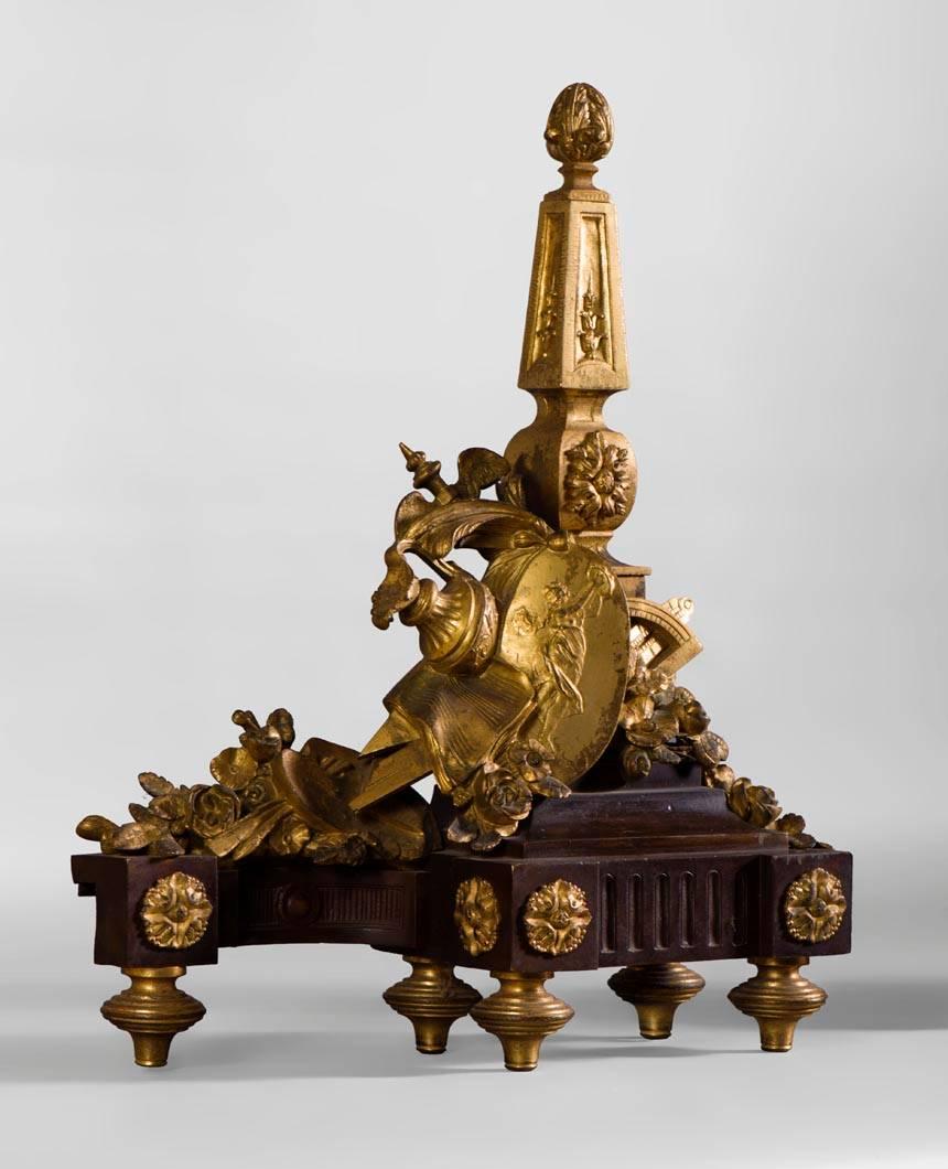 This pair of Louis XVI style andirons was made in the 19th century.
The patinated bronze base highlights the rosette patterns and a beautiful carved gilt bronze decoration.
Around obelisks summoned with pineapples are arranged the attributes of
