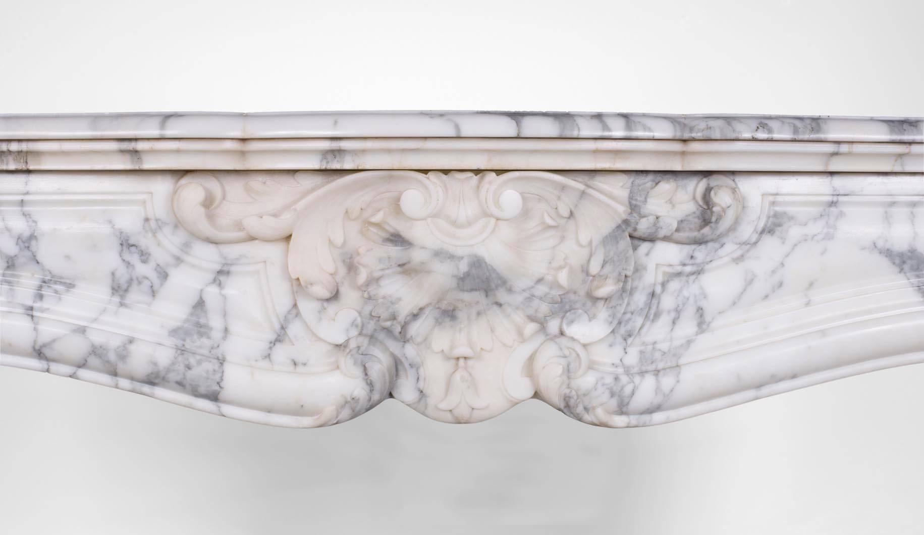 This Louis XV style fireplace was made in the 19th century. It is a model with three shells carved in an Arabescato marble (coming from the Carrara area, Italy).

This fireplace is sold without any fireplace insert nor marble floor but could be