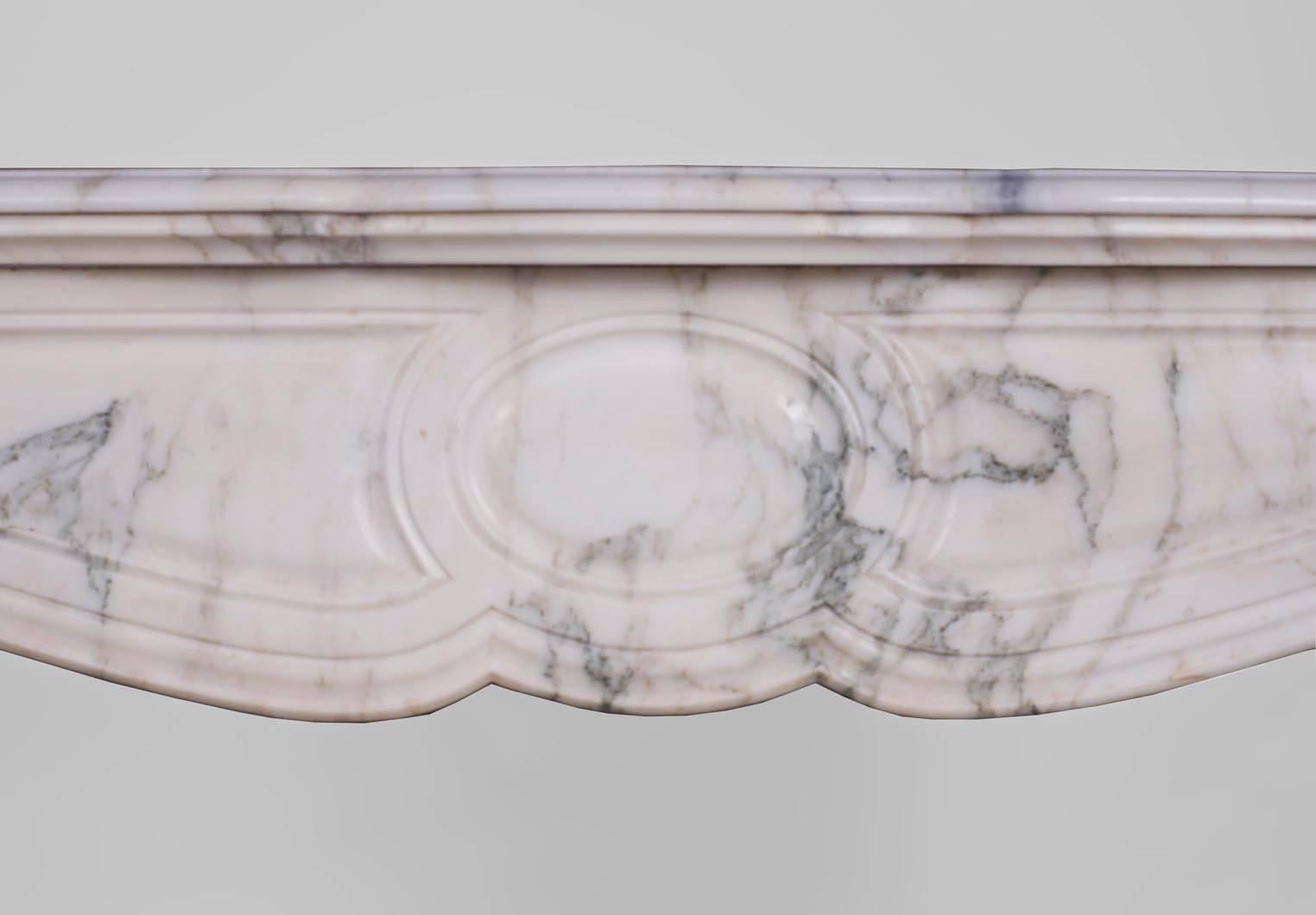 This Louis XV style fireplace was made in the 19th century. It is a Pompadour model, with the typical medallion on the frieze, and the paneled curved legs. Its Arabescato marble has gray veins.
This fireplace is sold without any fireplace insert