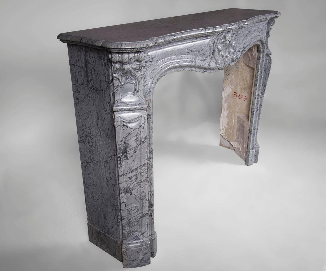Carved Antique Louis XV Style Fireplace, in Bleu Fleuri Marble, with Three Shells Decor For Sale
