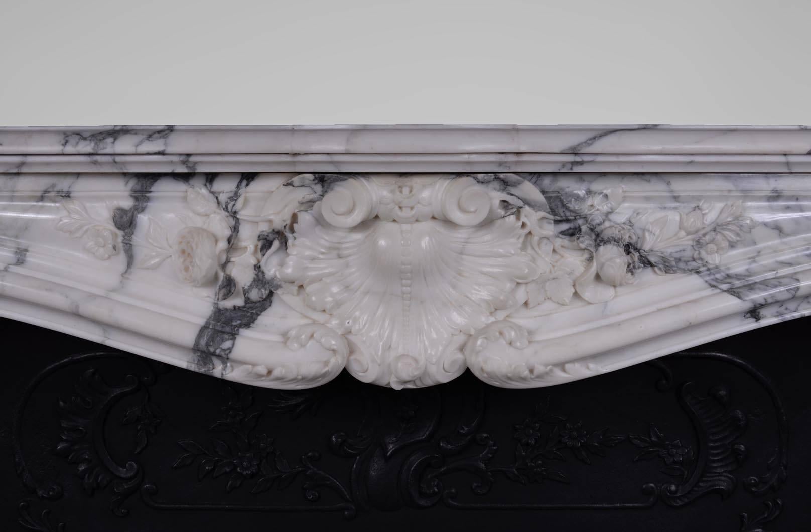 Very beautiful antique Louis XV style fireplace with rich decor made out of Arabescato marble during the 19th century.

This fireplace is sold with its original cast iron insert but without any marble floor. This one could be made to order.