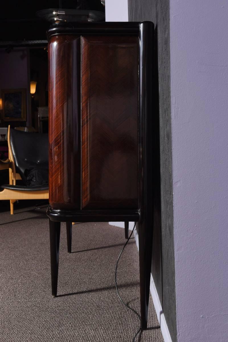 Italian origin Art Deco bar-cabinet in dark rosewood. In the middle two doors opening to a bar, the inside is covered with small cut mirrors, one glass shelf in the middle. The two other doors open to a cabinet on each side, hiding two wooden