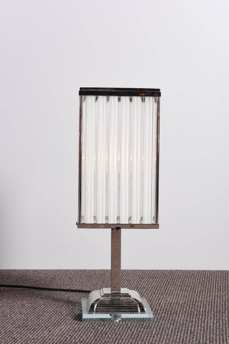 A very elegant pair of lamps designed in the spirit of modernist Art Deco. The frame and base are in nickel-plated metal, the shade is composed by transparent and edged glass. The metallic base is supported by a transparent glass plate.