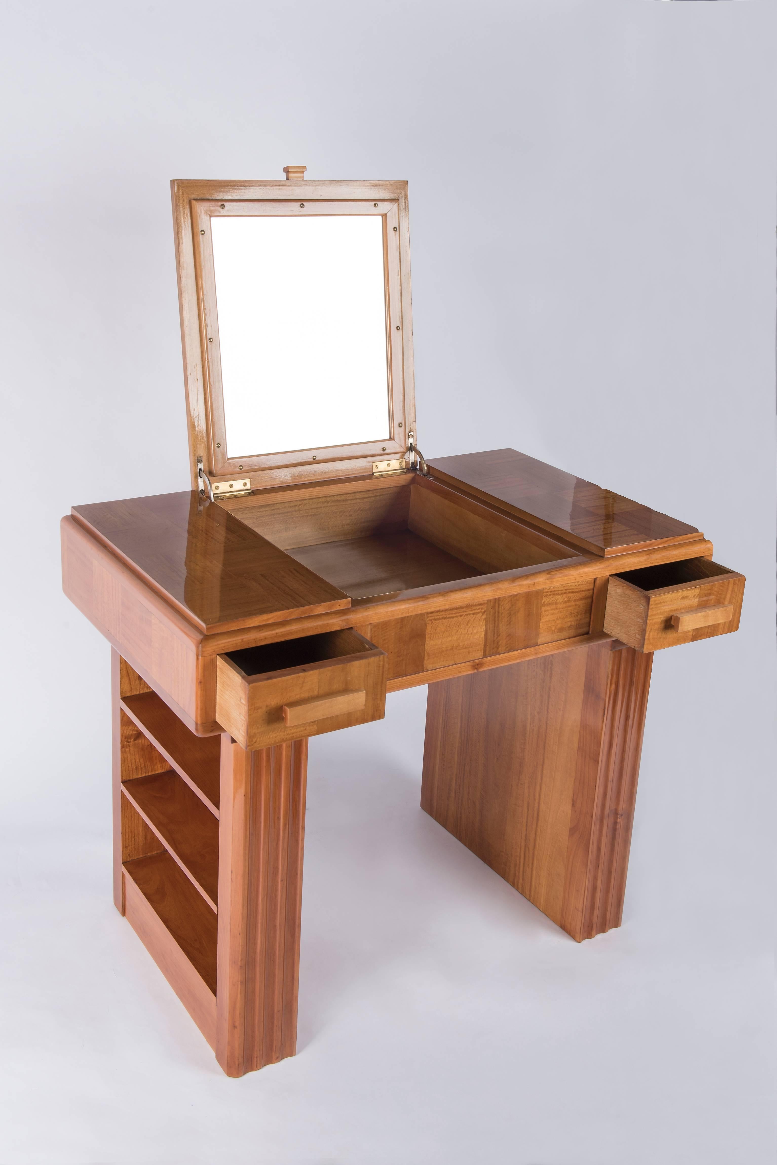 1930's lemonwood veneered french origin art-deco vanity.It can be used as well as a small desk .
Top opening to a small cabinet,mirror inside of the top.Two drawers,one on each side.Wooden handels.Small shelves on both sides .Veneered and polished