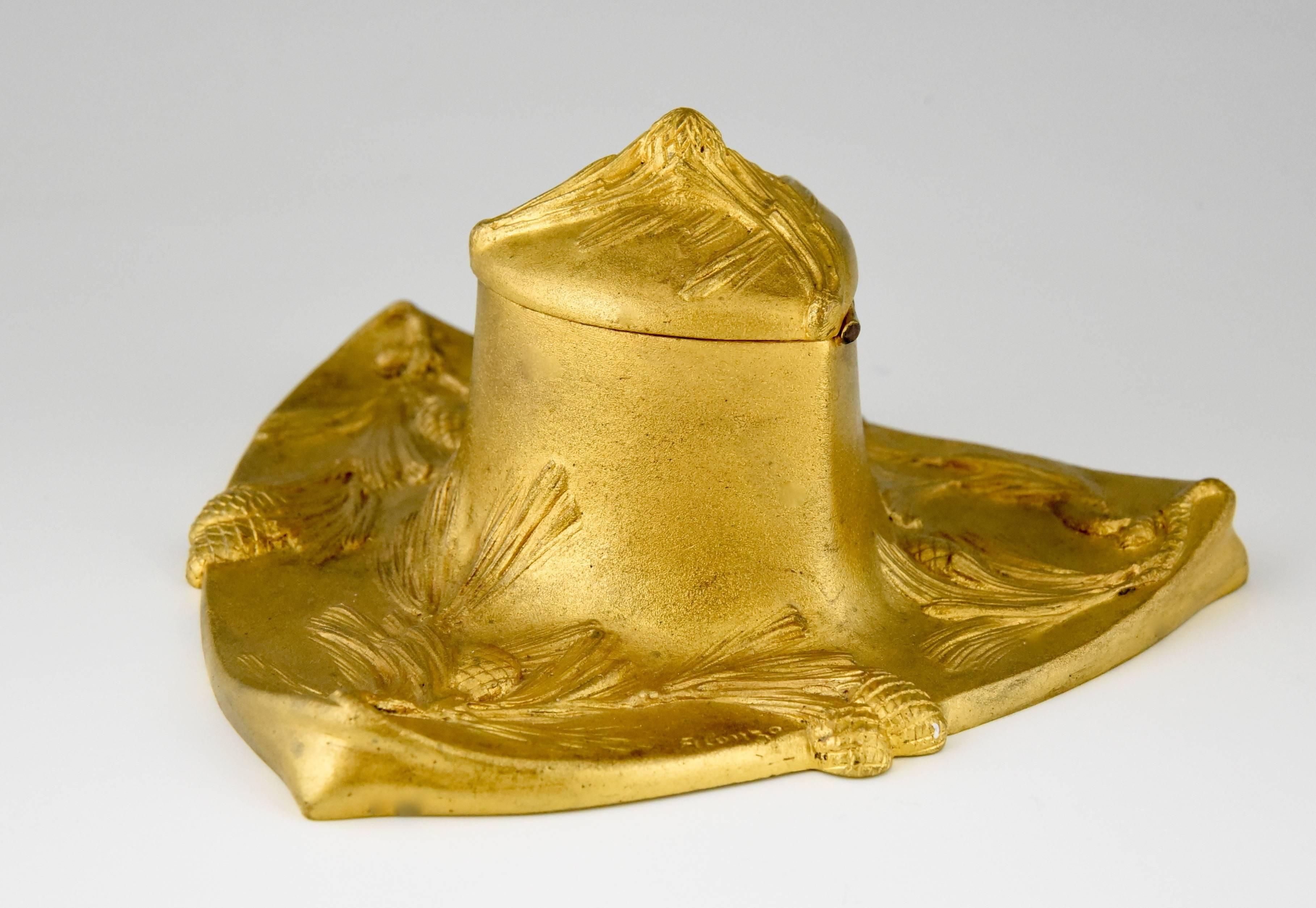 An Art Nouveau gilt bronze inkwell with decoration of pine cones. By the French artist Dominique Alonzo.

Artist / maker:
D. Alonzo.
Signature / marks:
Alonzo, stamped D and numbered.
Style:
Art Nouveau.
Date:
1900
Material:
Gilt bronze.