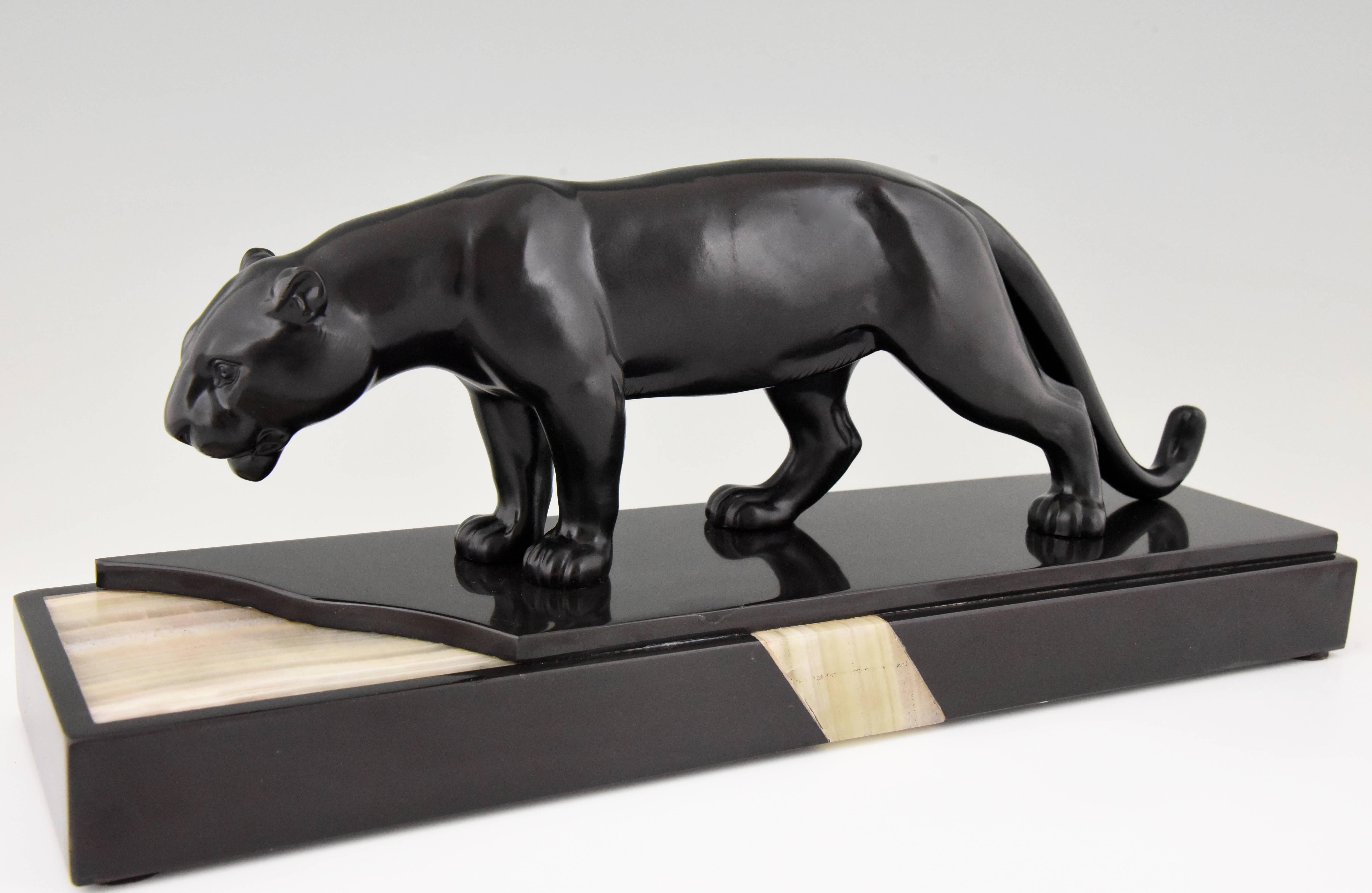 Art Deco sculpture of a panther drinking at the waterside. The black marble and onyx base gives the sculpture a special effect. Signature/ marks: Luc. Style: Art Deco. Date: 1930. Material: Patinated art metal. Black marble and onyx base. Origin: