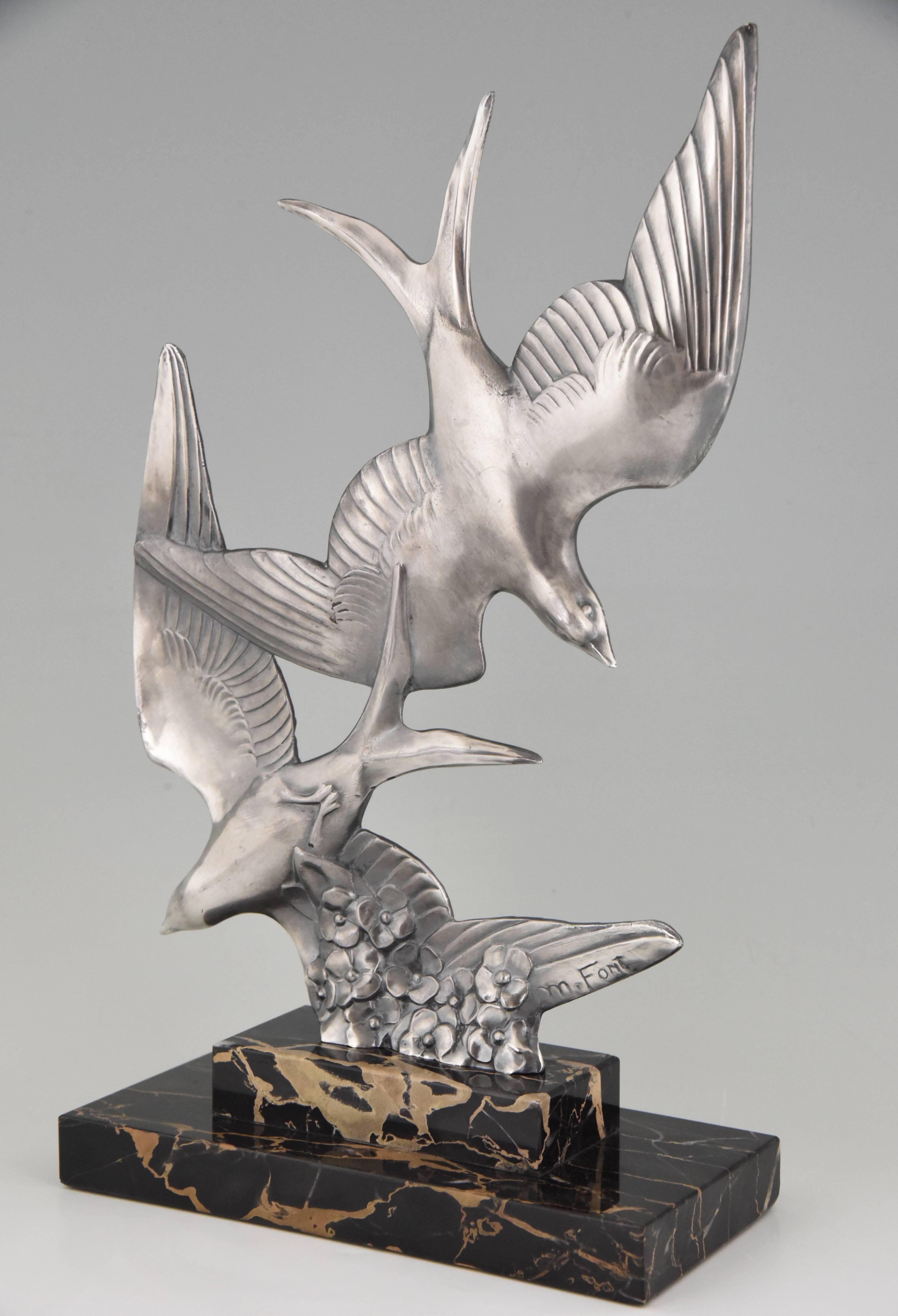 Beautiful Art Deco sculpture of two birds in flight by the French artist M. Font on a portor marble base. 

Artist/ maker: M. Font
Signature/ marks: M. Font.
Style: Art Deco
Date: 1930
Material: Metal with old silver patina. Portor marble