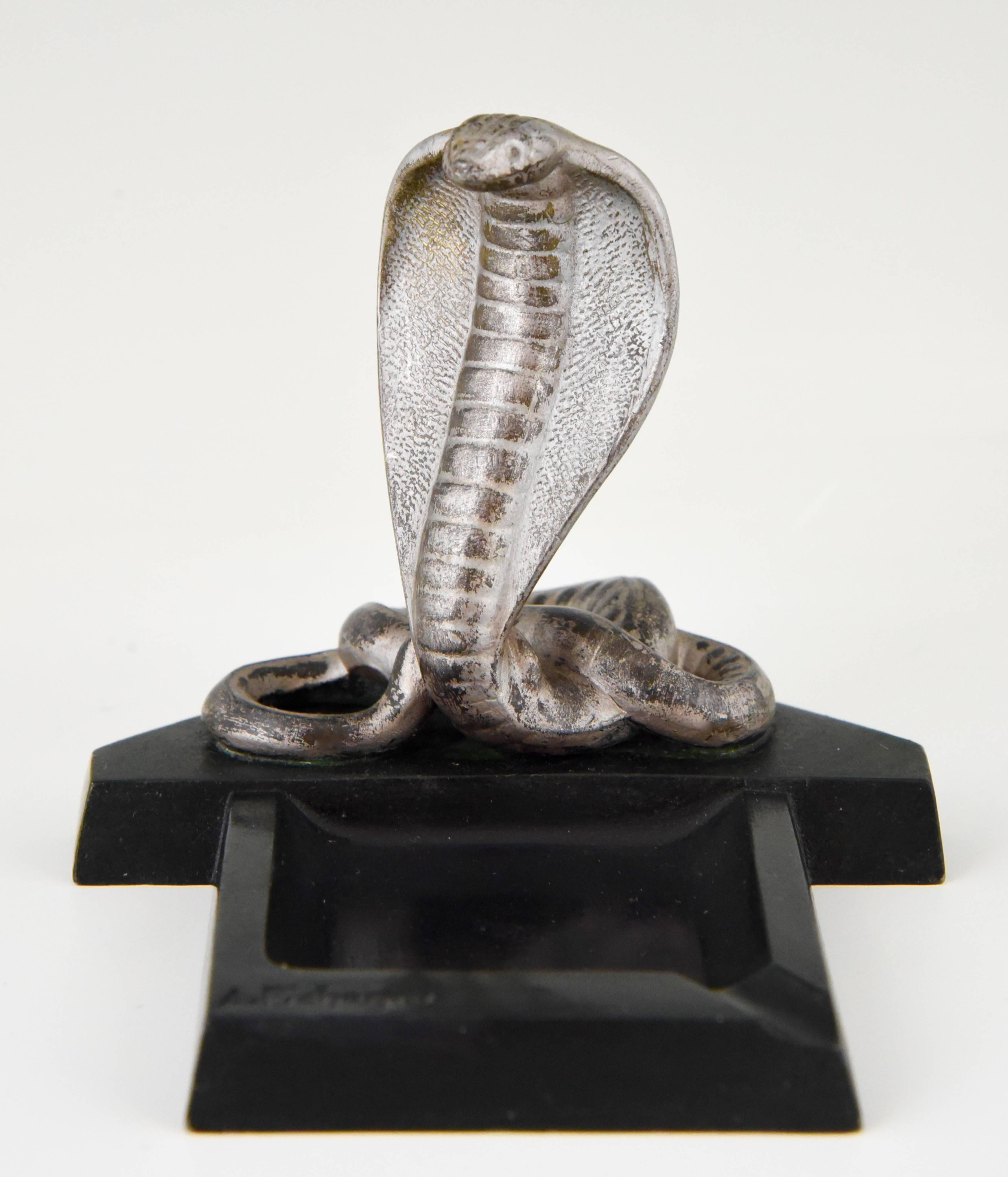 French Art Deco cobra snake ashtray.

Artist/ maker: Pichegru.
Signature/ marks: Pichegru
Style: Art Deco
Date: 1930
Material: Patinated art metal.
Origin: France
Size: H 9.3 cm x L 12 cm. x W 10 cm.
H. 3.7 inch x L. 4.7 inch. X W. 3.9