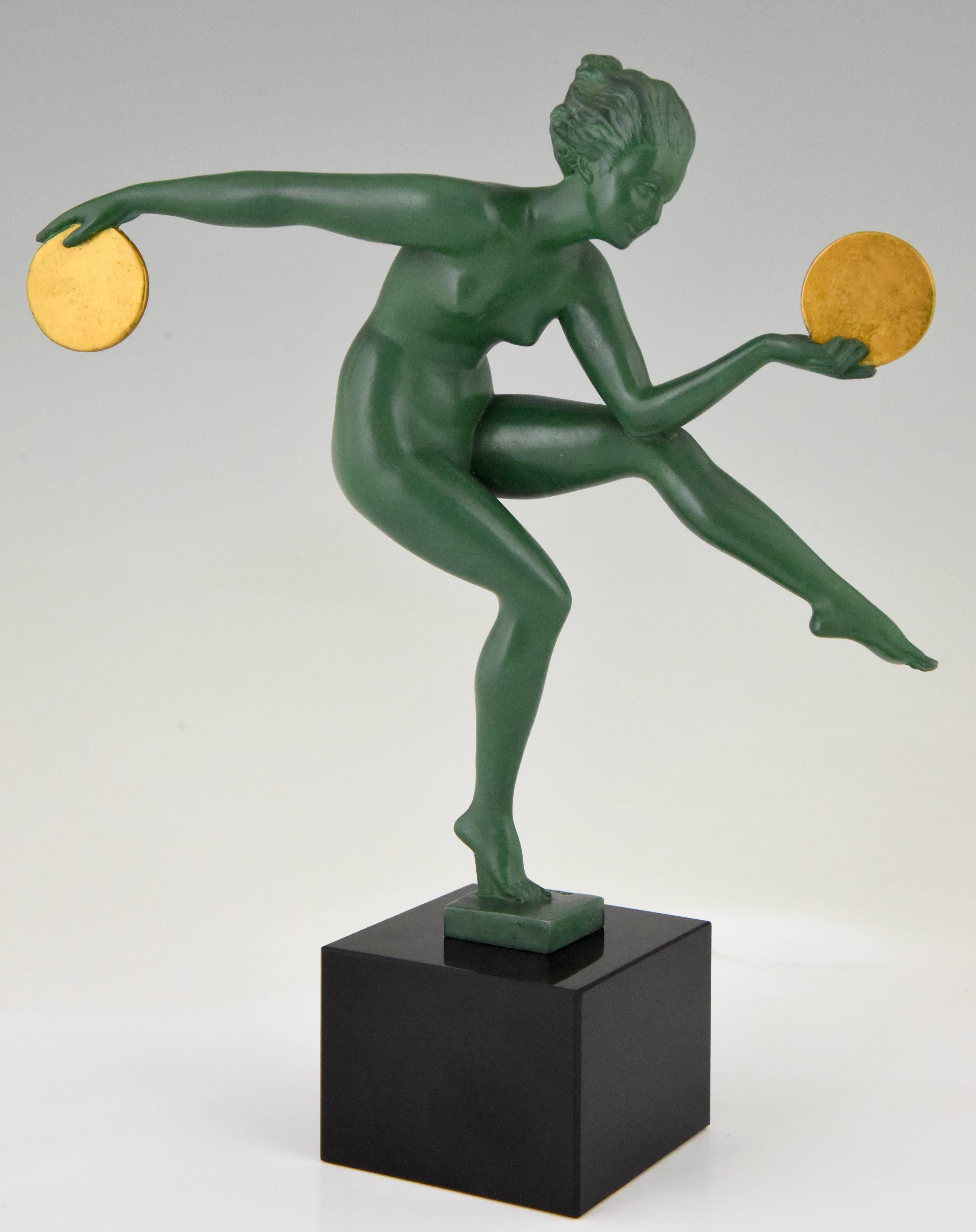 Typical Art Deco figure of a dancing nude with discs by Marcel Bouraine, Derenne. 
Signature / Marks: Derenne
Style: Art Deco
Date: 1930
Material: Patinated art metal, green and gold. Belgian black marble base.
Origin: France
Size: H. 26.5 cm