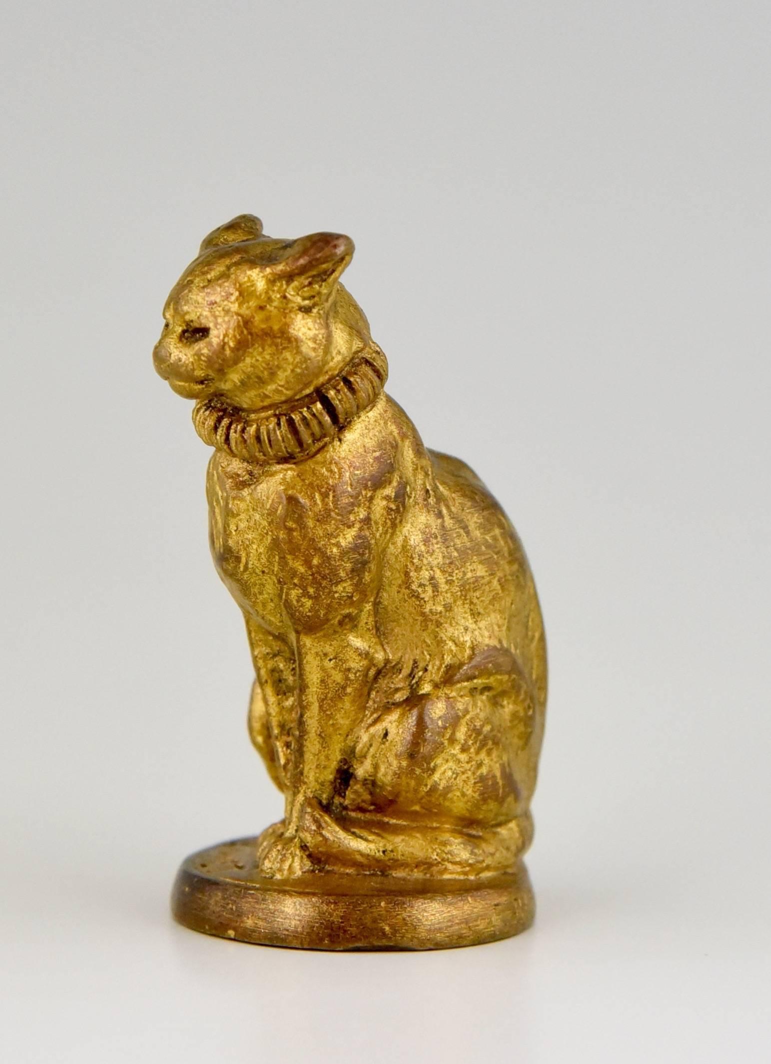 A gilt bronze letter seal in the shape of a sitting cat.