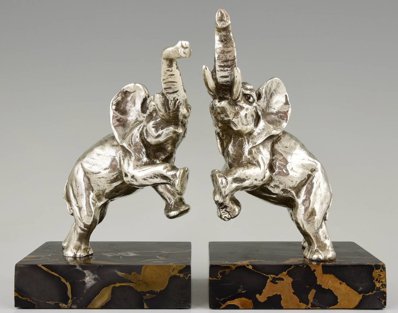 Description:  Art Deco silvered bronze elephant bookends.
Artist/ Maker:  Jean de la Fontinelle.
Signature/ Marks:  L. Fontinelle. 
Style:  Art Deco. 
Date:  1930. 
Material:  Silvered bronze.  Portor marble base. 
Origin:  France. 
Size of one:  
H