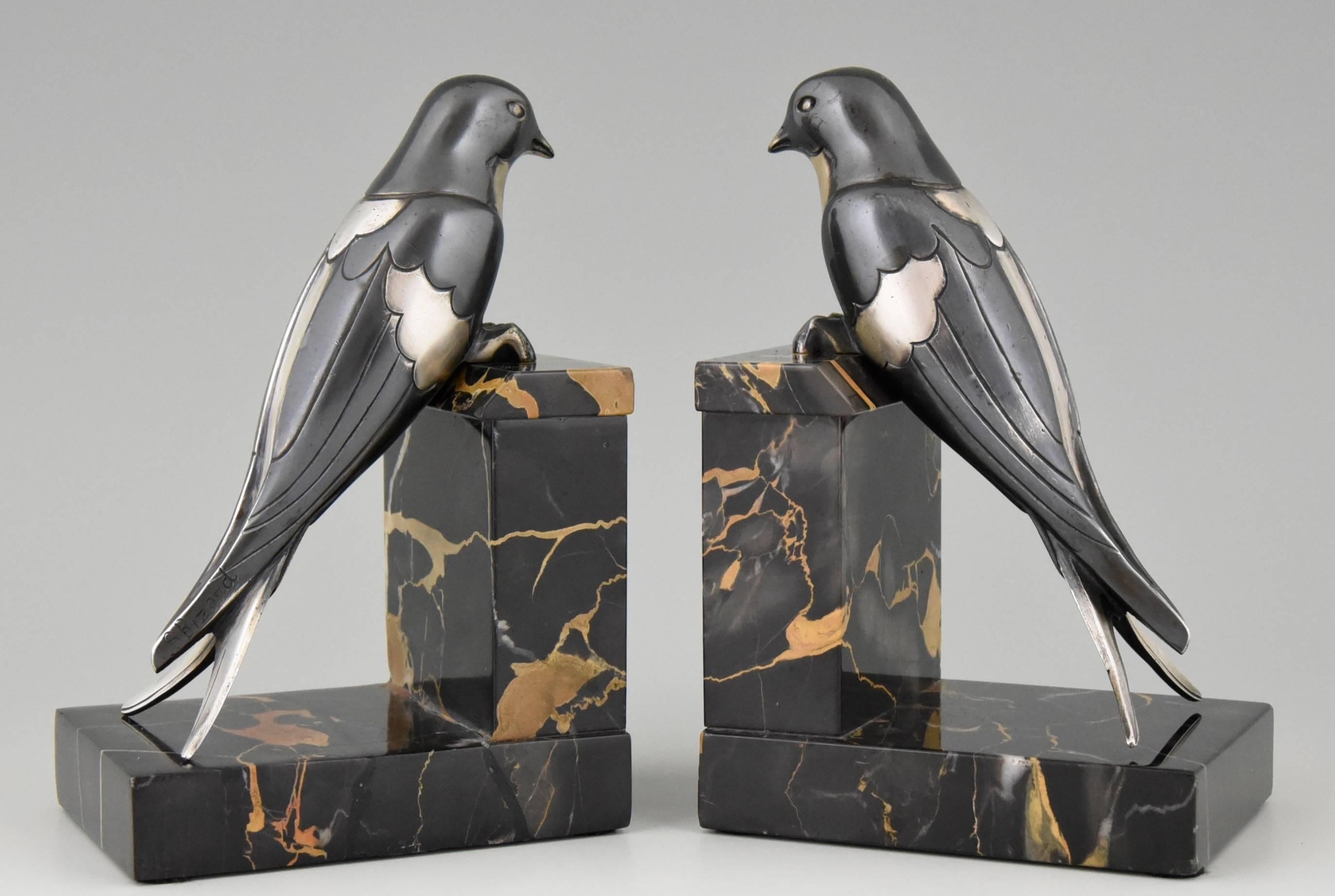 Description: Art Deco bronze swallow bookends. Artist / Maker: Suzanne Bizard. Signature / Marks: S. Bizard. Style: Art Deco. Date: 1930. Material: Silvered and blackened silvered bronze. Portor marble bases. Origin: France. Size of one: H 15.5 cm.