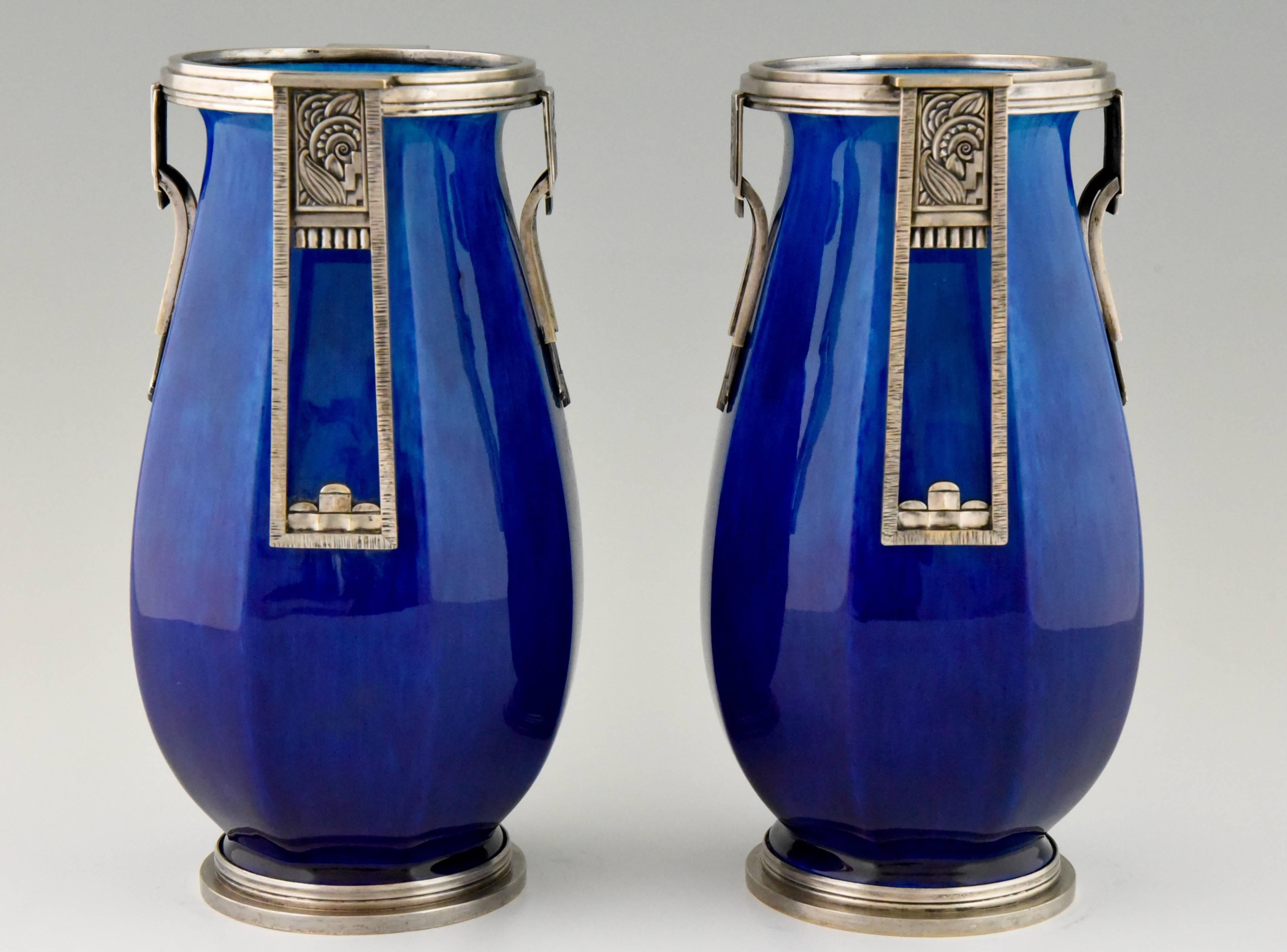 A pair of French Art Deco ceramic vases with blue glaze and silvered bronze decorations. Artist / Maker:  Paul Milet (1870-1950) son of Optat Milet. Maker:  Sèvres. Signature/ Marks:  MP and Sèvres dotted circle logo. Style: Art Deco. Date: 1925.