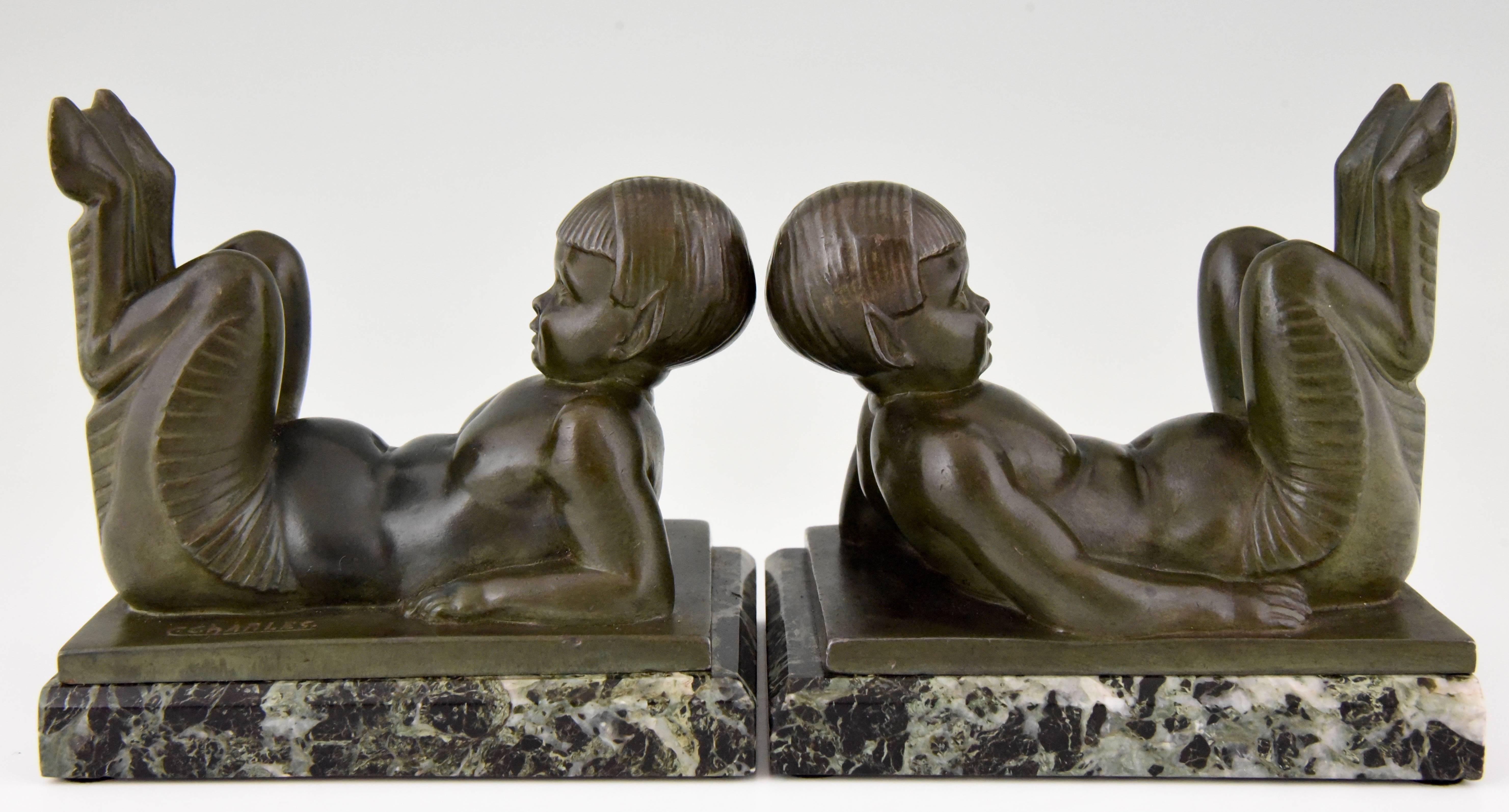 Lovely pair of Art Deco bookends with lying young satyrs by the French artist C. Charles.

Artist/maker: Charles Charles.
Signature/marks: C. Charles.
Style: Art Deco.
Date: 1930.
Material: Art metal with green patina on green marble