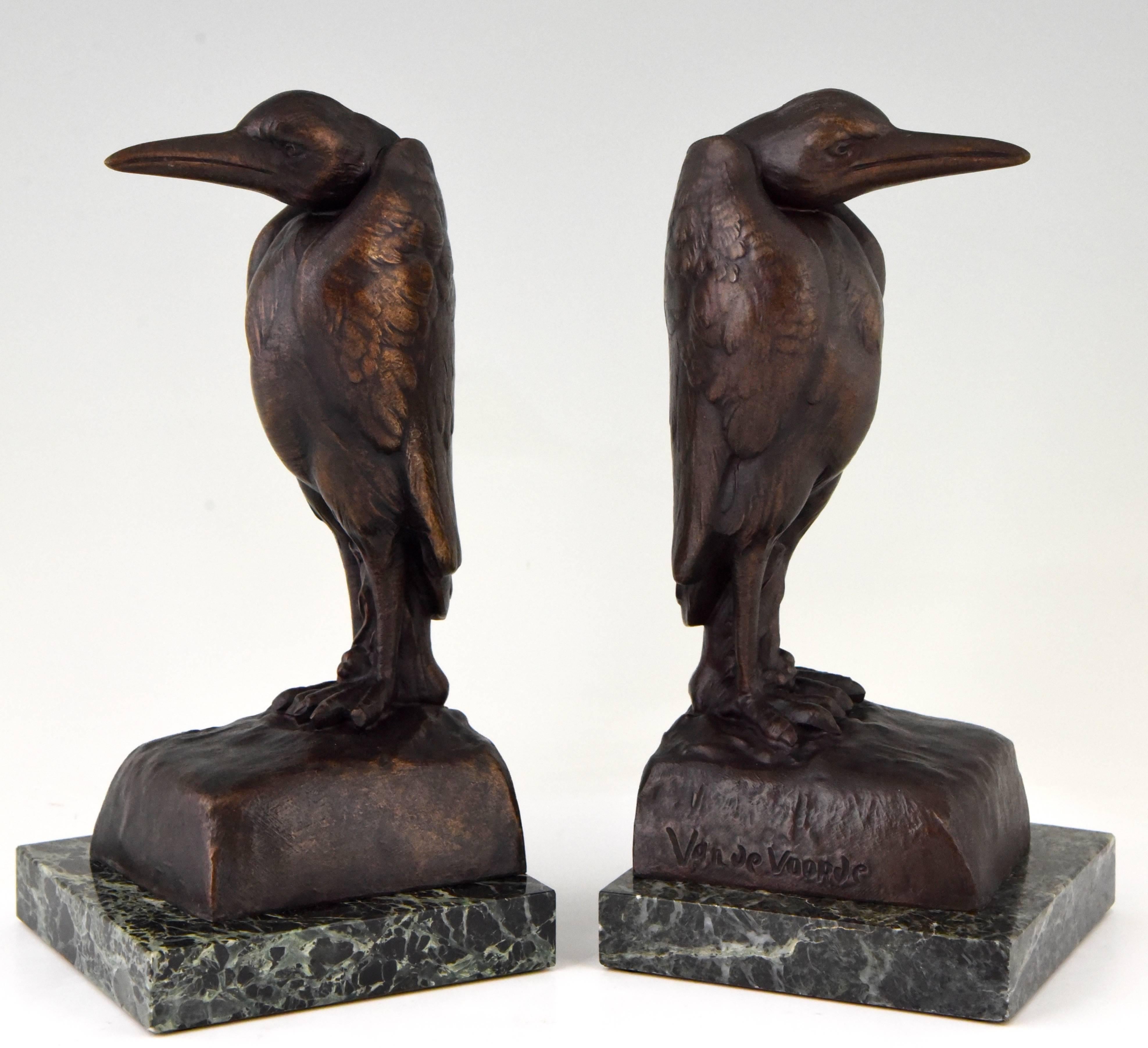 Decorative Art Deco bookends in the shape of Marabous by the French artist Georges van de Voorde. These figures are in art metal and have a lovely brown patina. They stand on a green marble base. Signed by the artist and with foundry
