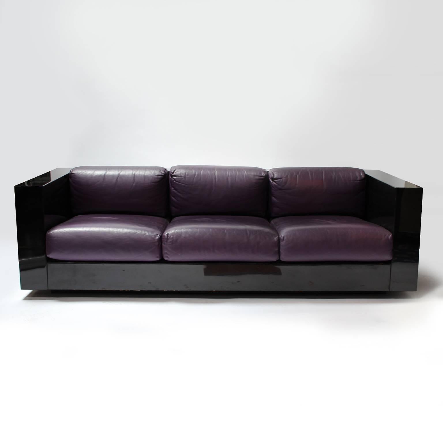 Living room set by Massimo & Lella Vignelli for Poltronova composed of a three-seater sofa, two armchairs and a coffee table.

Black lacquered wood structure with violet leather seats.

Three-seat: W 210 x D 90 x H 61 cm.
Armchair: W 90 x D 90