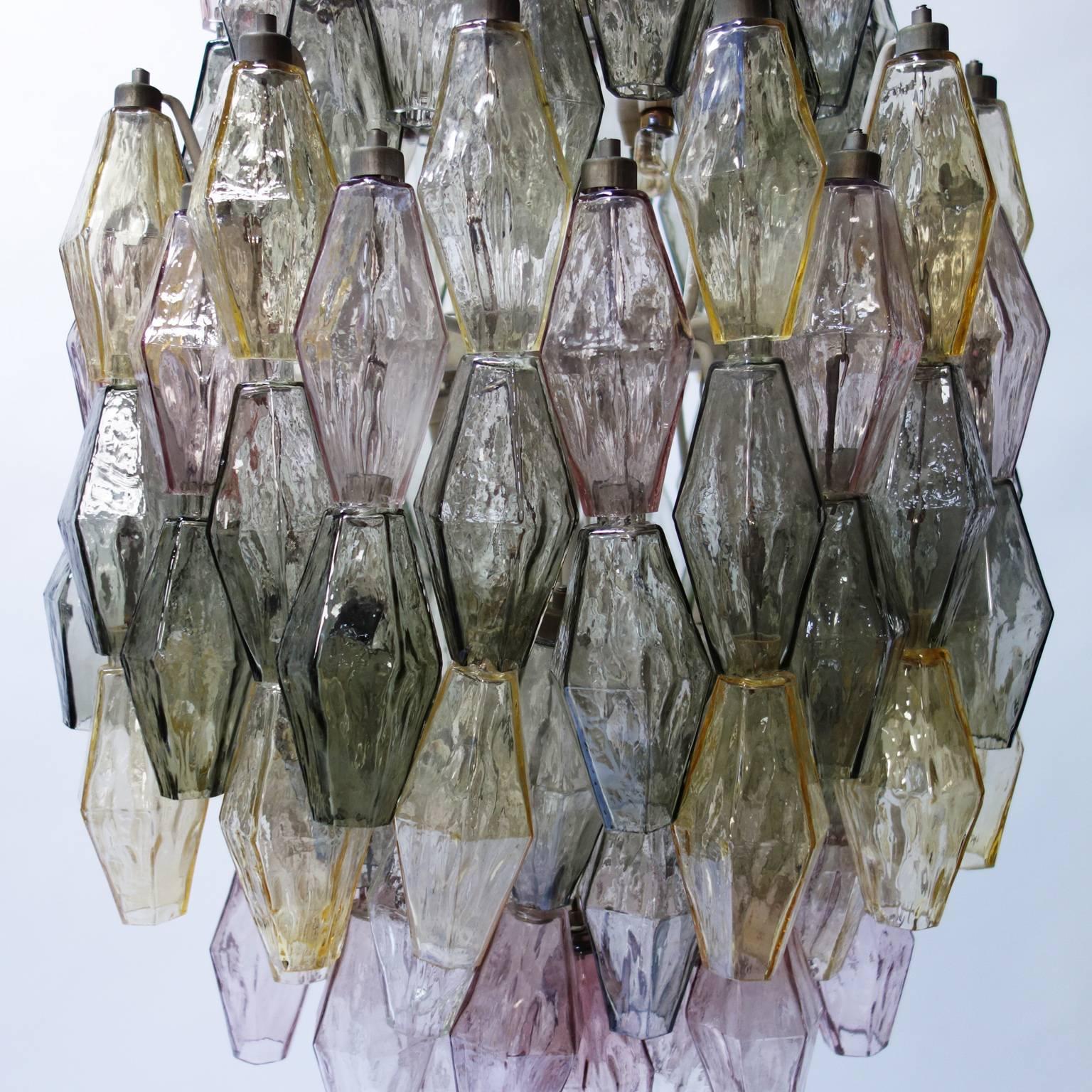A large Venini chandelier with polyhedral Murano glass elements hanging at several levels from four metal tiers. 

Inside there are small light bulbs.
This lamp was designed by Carlo Scarpa, circa 1958, and is in a great and fully original