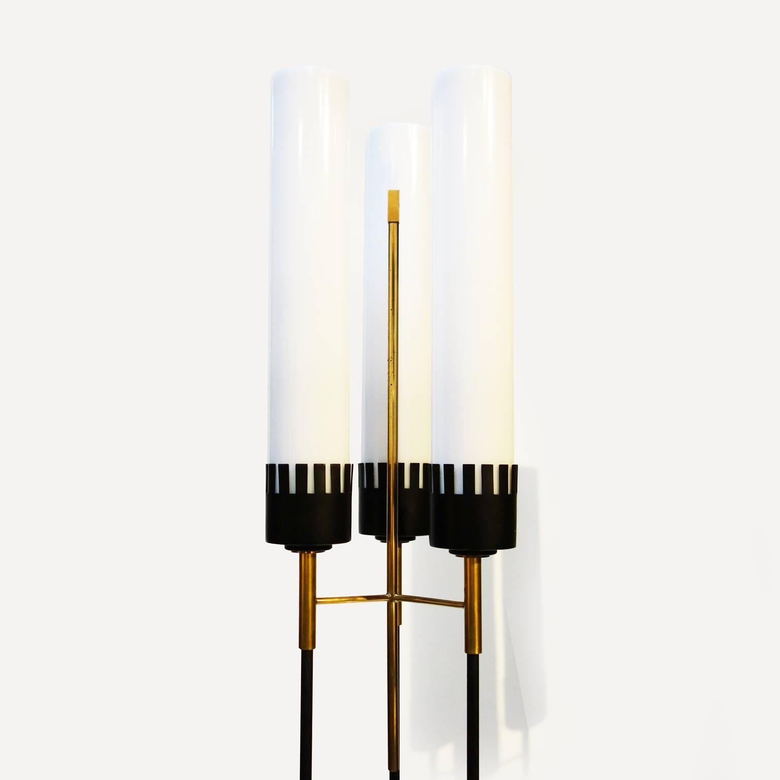 Pair of Italian torchiere in the style of Angelo Lelli

Matte black lacquered metal structure with polished brass details, white perspex cylindrical lampshade.

Electrical wiring up to European standard: 220 volts. Sockets E27.