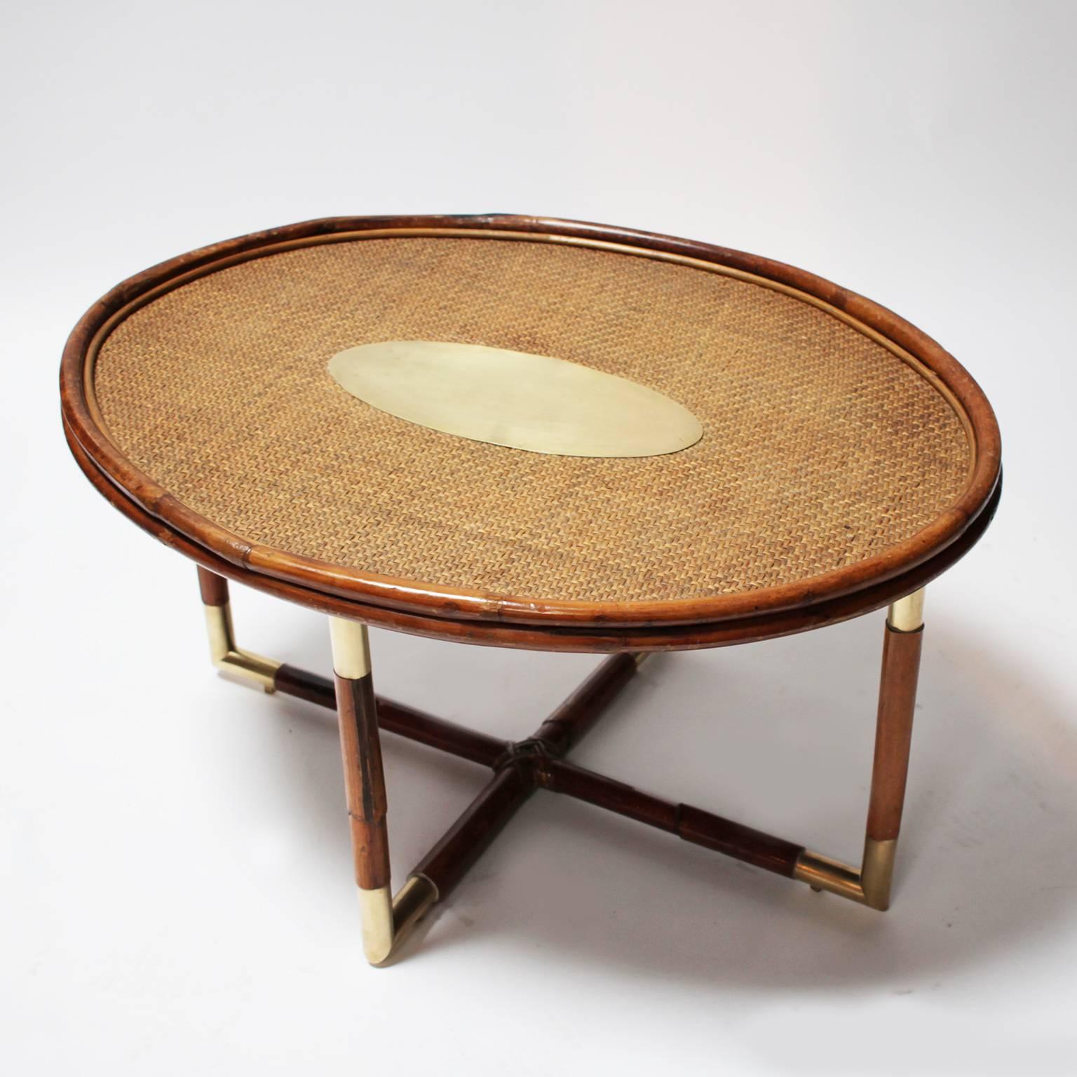 Elegant bamboo coffee table in the style of Gabriella Crespi.
Tabletop in woven bamboo with a polished brass ovoïdal center,
bamboo legs with brass junctions and details.