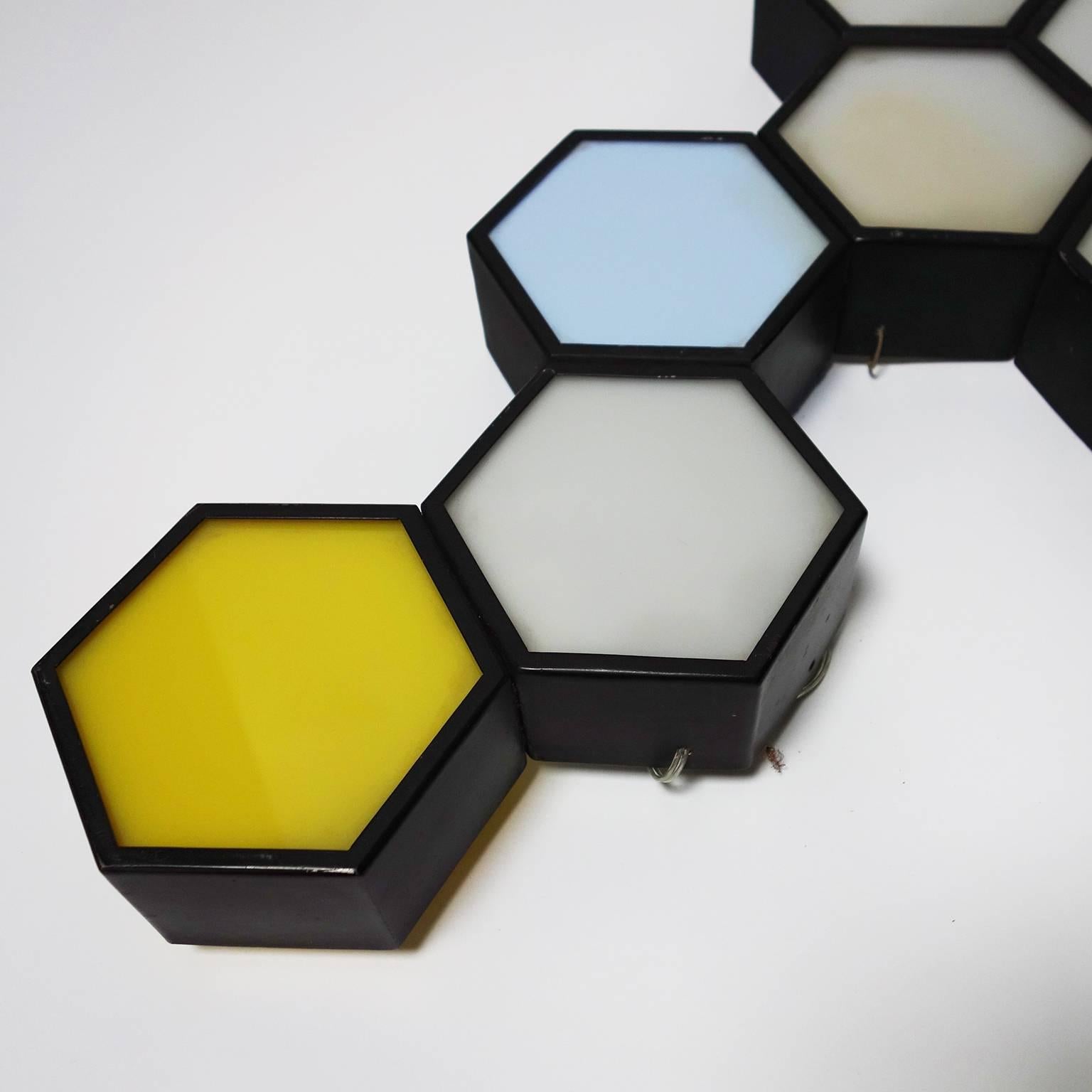 Italian sconce composed two ensembles of metal hexagons with colored plastic lampshades.

Measurements of each sconce:

Large: Width 86 cm, height 52 cm, depth 7 cm.
Small: Width 38 cm, height 26.5 cm, depth 7 cm.