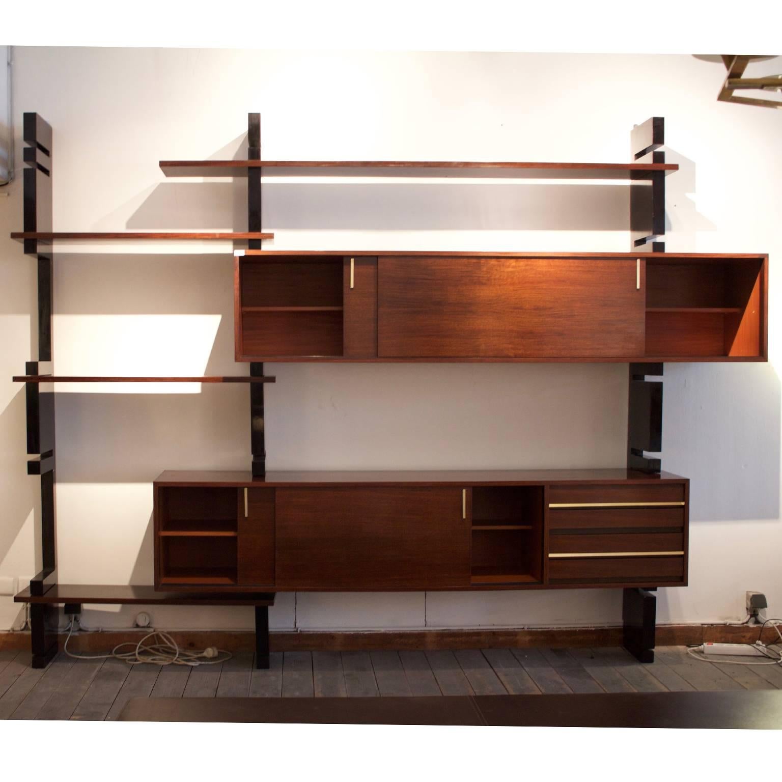 Modular system composed by black lacquered uprights and rosewood shelves and sliding doors cabinets.
Beautiful brass hand grips and a clear configuration that allows simple positioning changes of the shelves and cabinets.