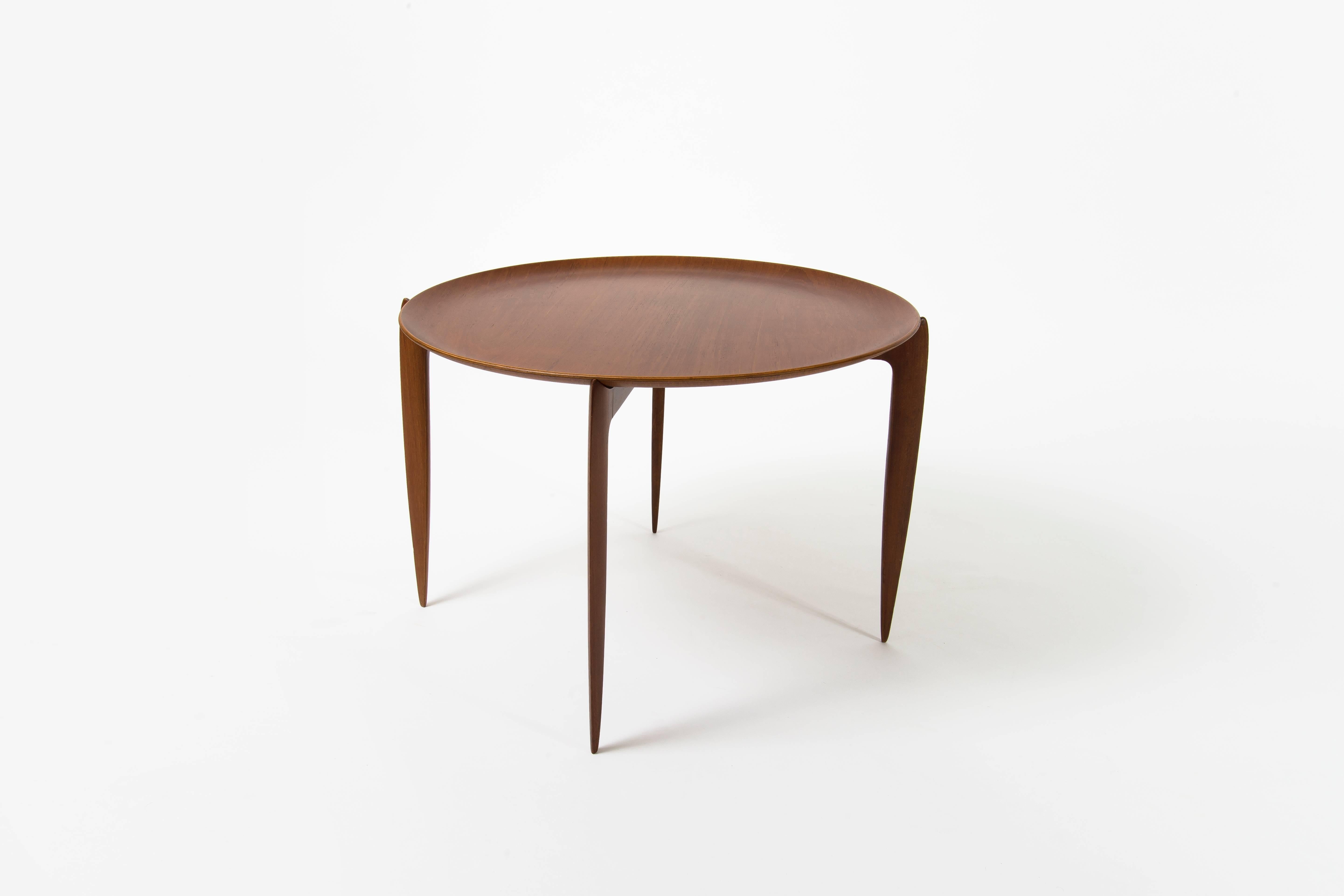 Occasional table executed by Fritz Hansen, Denmark, made of solid and veneer teak. Signature on the back of the removable top (see last image).