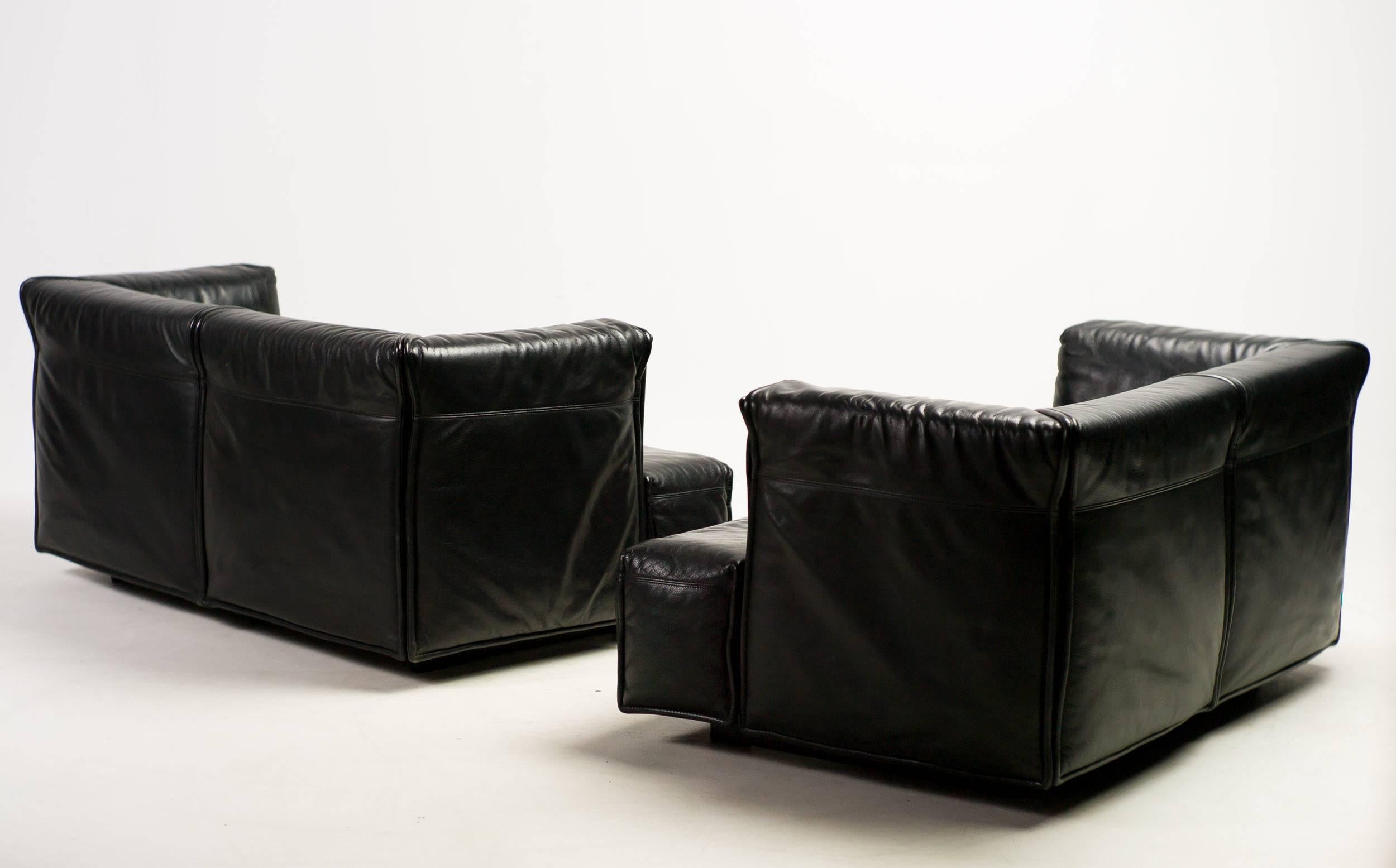 Set of two sofas in black leather, designed in 1968 by Vico Magistretti. 

Excellent fast and affordable worldwide shipping.
White glove delivery available upon request.