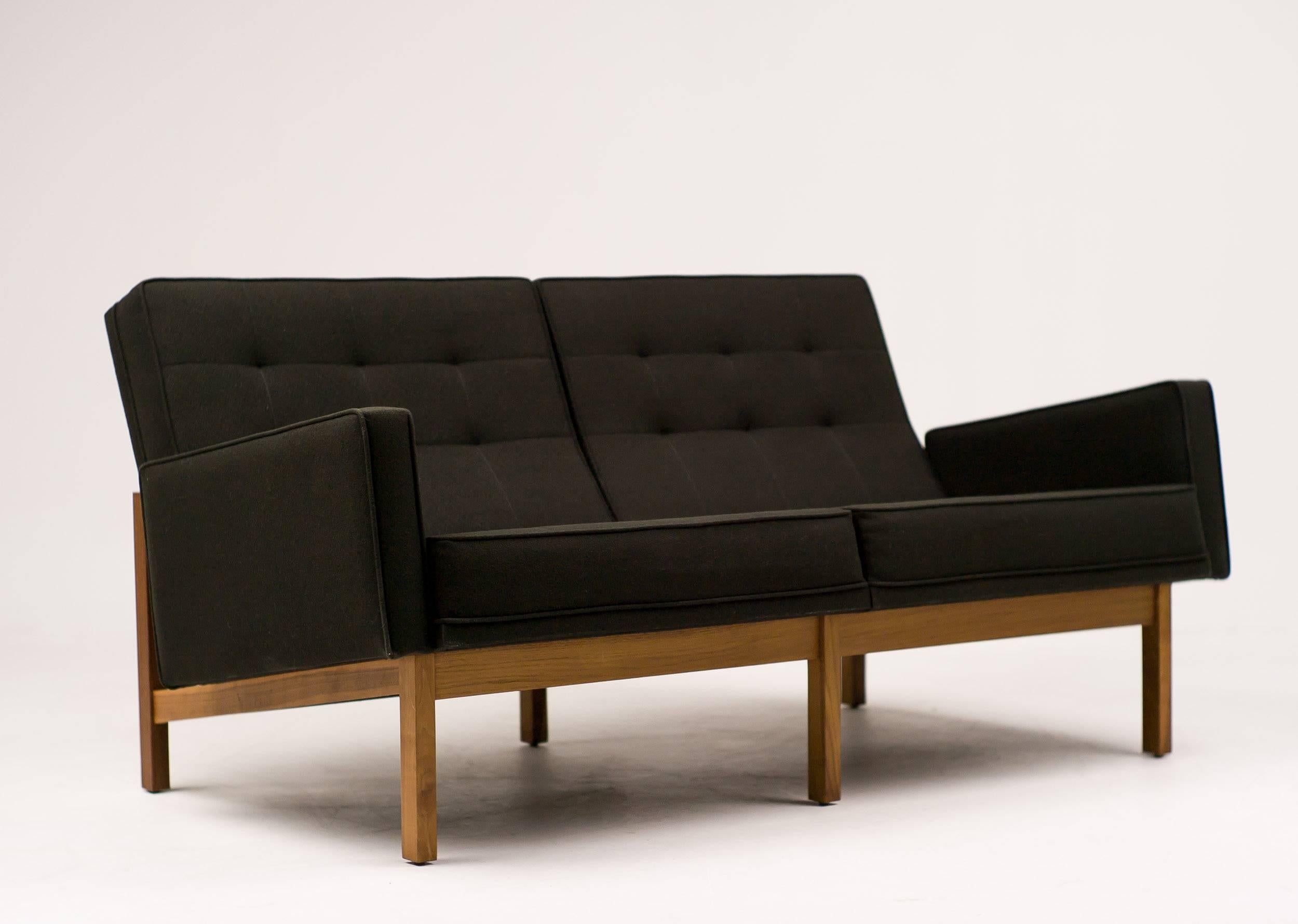 Split rail two-seat sofa in walnut with charcoal fabric designed by Florence Knoll, manufactured by Modernica.

Excellent fast and affordable worldwide shipping.
White glove delivery available upon request.