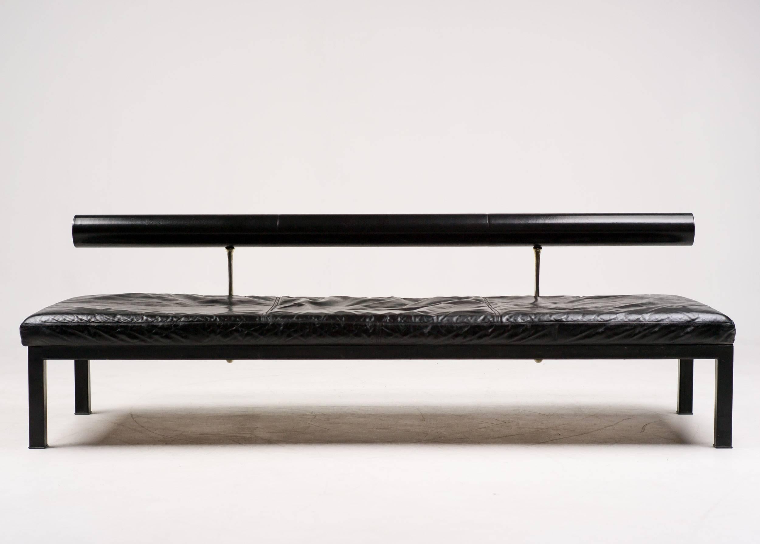 This early Sity daybed was designed by Antonio Citterio and manufactured by B&B Italia in the 1980s. It features a black leather covered frame with four legs and a steel supported wooden platform with embossed manufacturer or designer label. The
