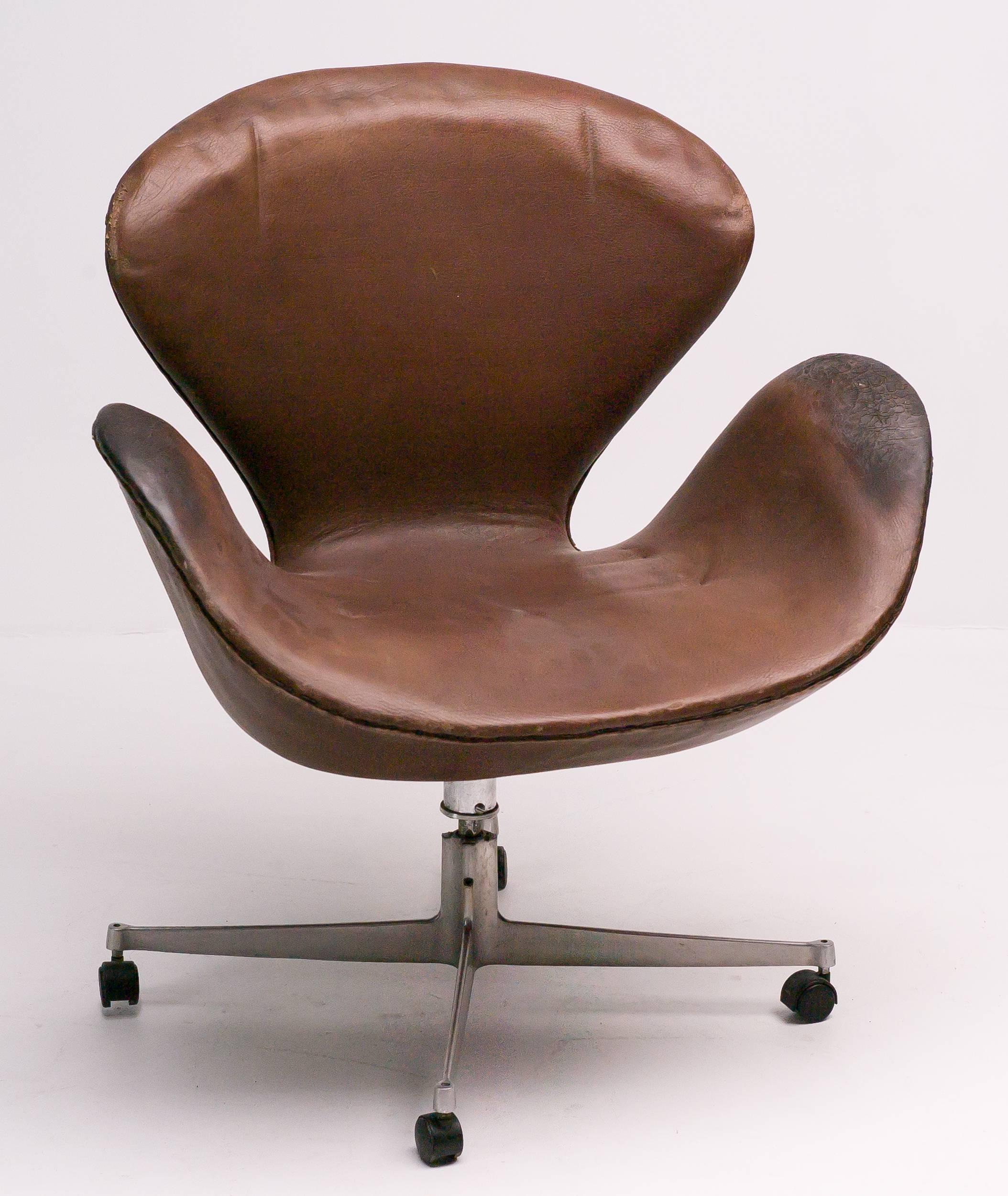 Early very unusual adjustable tilt, swivel or wheels swan chair by Arne Jacobsen.
Marked with silver Fritz Hansen label.
Original leather upholstery, that is in fair condition.
The chair is useable as is, but is more a collector or museum