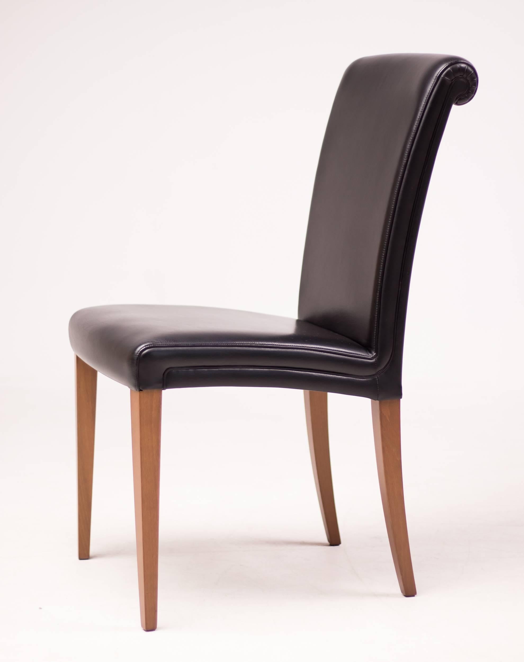 These elegant dining chairs are upholstered in black Pelle Frau leather. The birch legs are stained in cherry. They are in excellent original condition. Marked.

Excellent fast and affordable worldwide shipping.
White glove delivery available