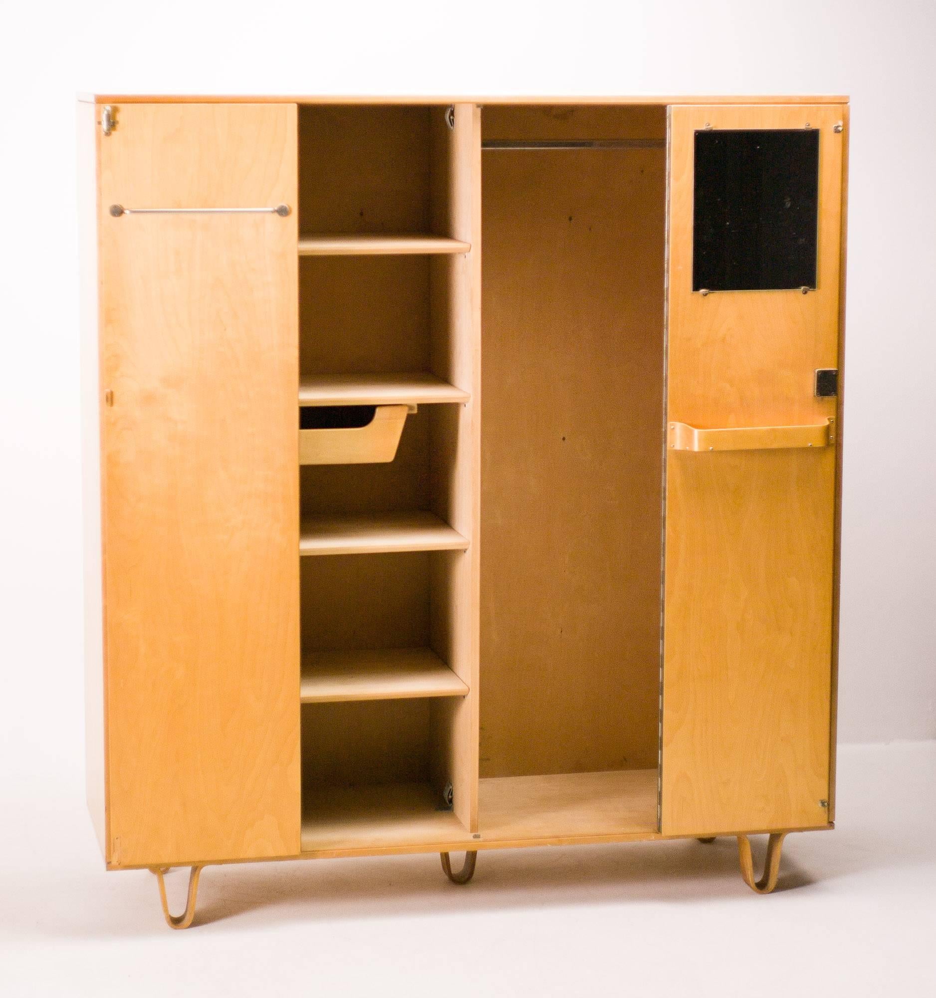 Large Pastoe wardrobe KB04 with the trademark bent plywood legs designed by Cees Braakman for Pastoe. From the first owner with completely original interior. Shelves, bent plywood drawer, bent plywood shelf, mirror, hanging rod. 
Check out the last