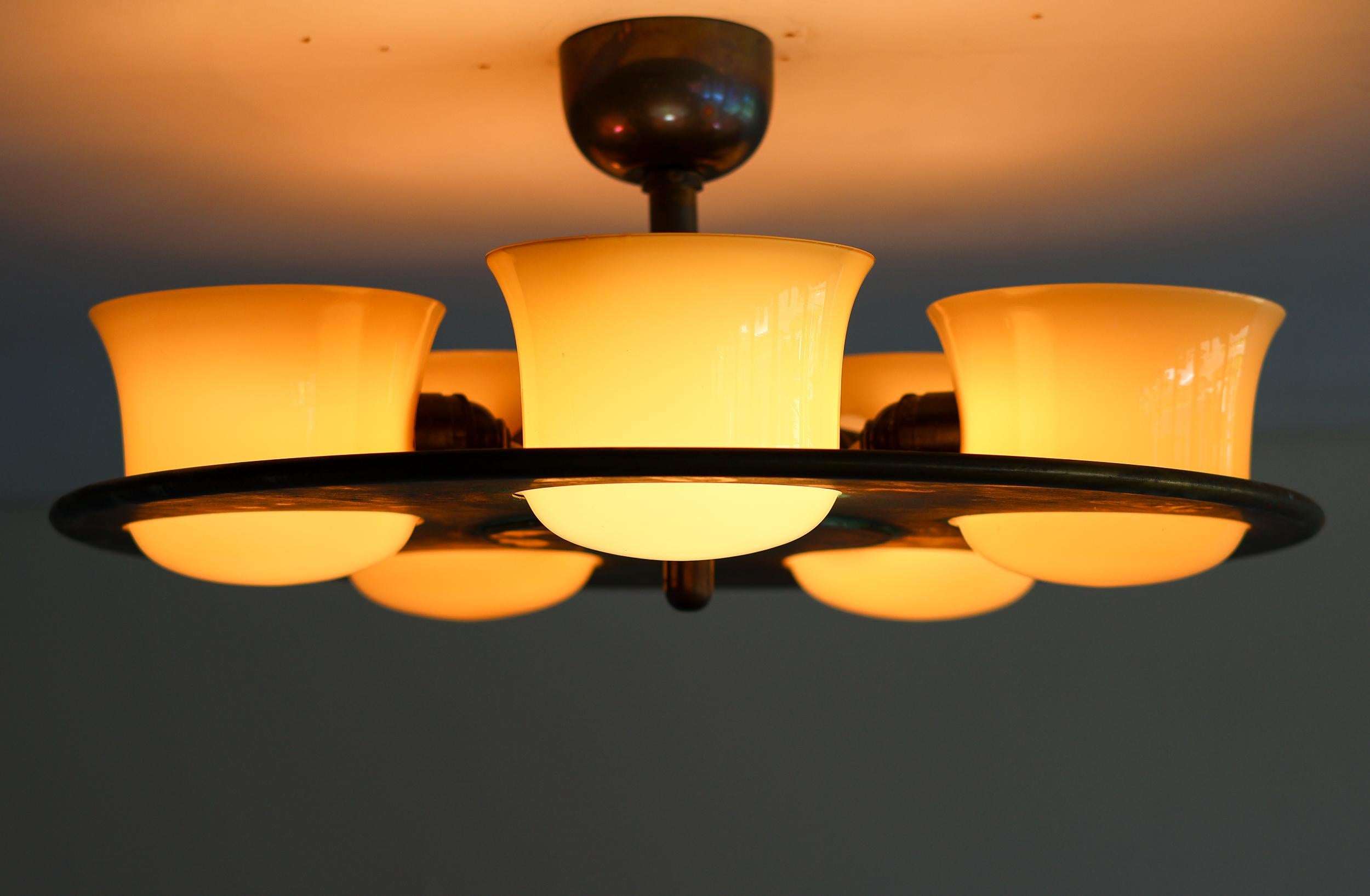 Lampadario Art Deco in ottone invecchiato e vetro soffiato - Illuminazione d'effetto con presenza architettonica

Progettato per elevare gli interni raffinati, questo lampadario Art Déco fonde forme scultoree con un'illuminazione calda e